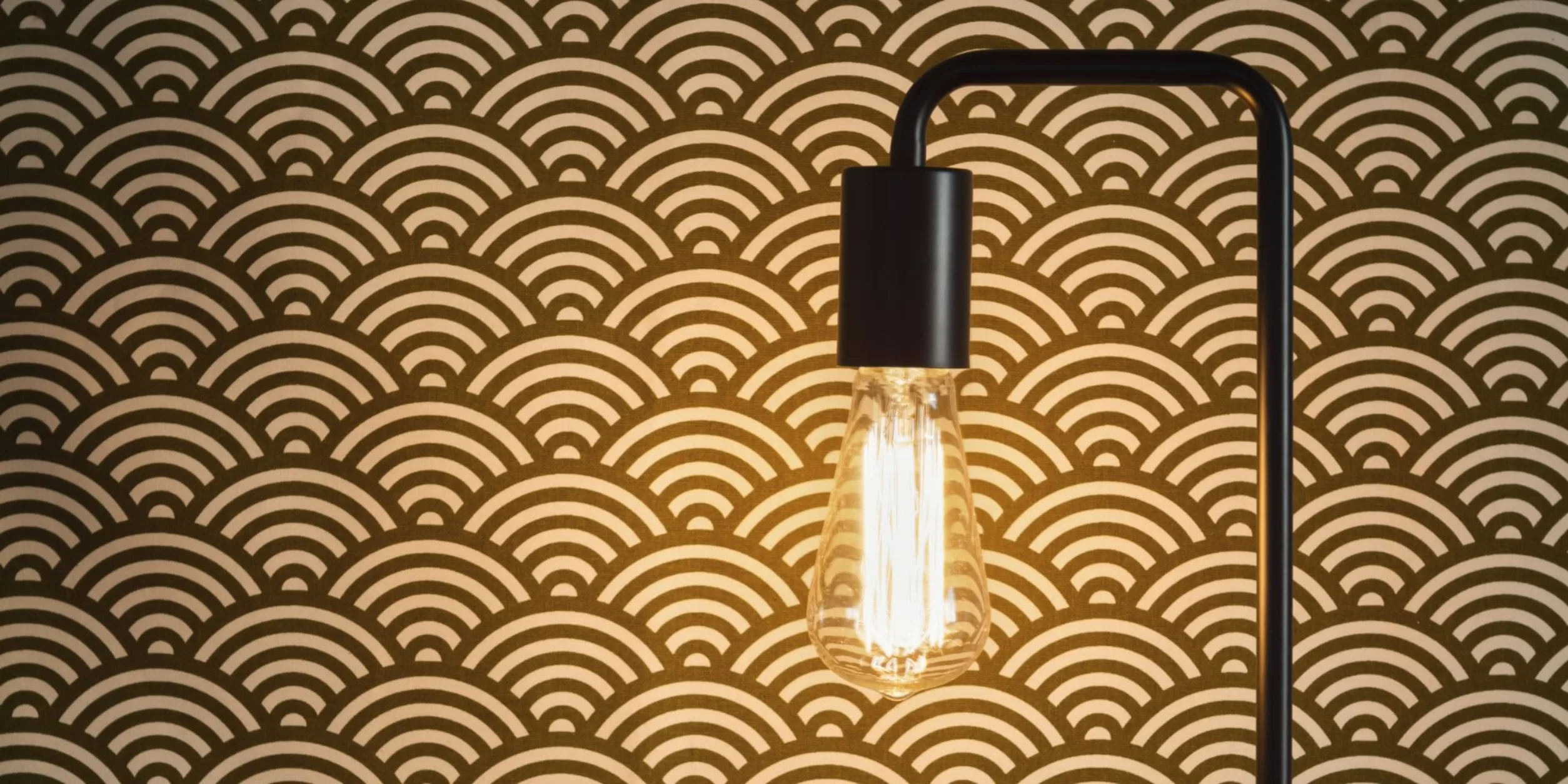 Eine Lampe vor einer Designertapete