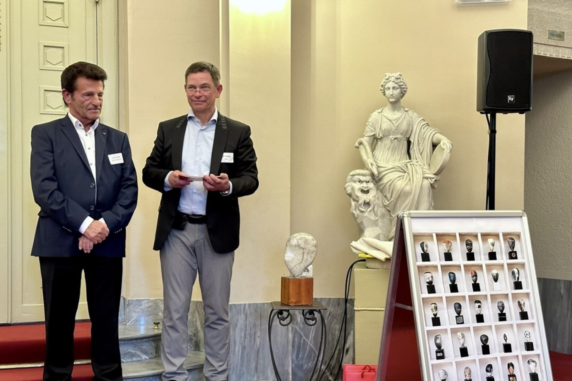 zwei Männer stehen vor Publikum