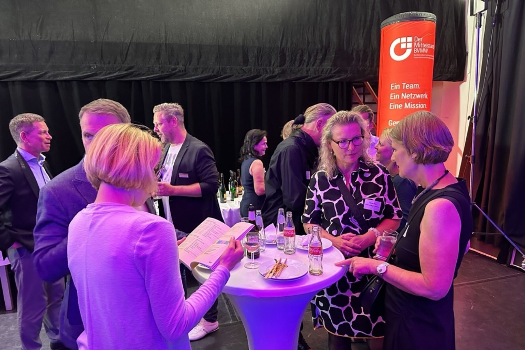 Menschen unterhalten sich an einem Stehtisch