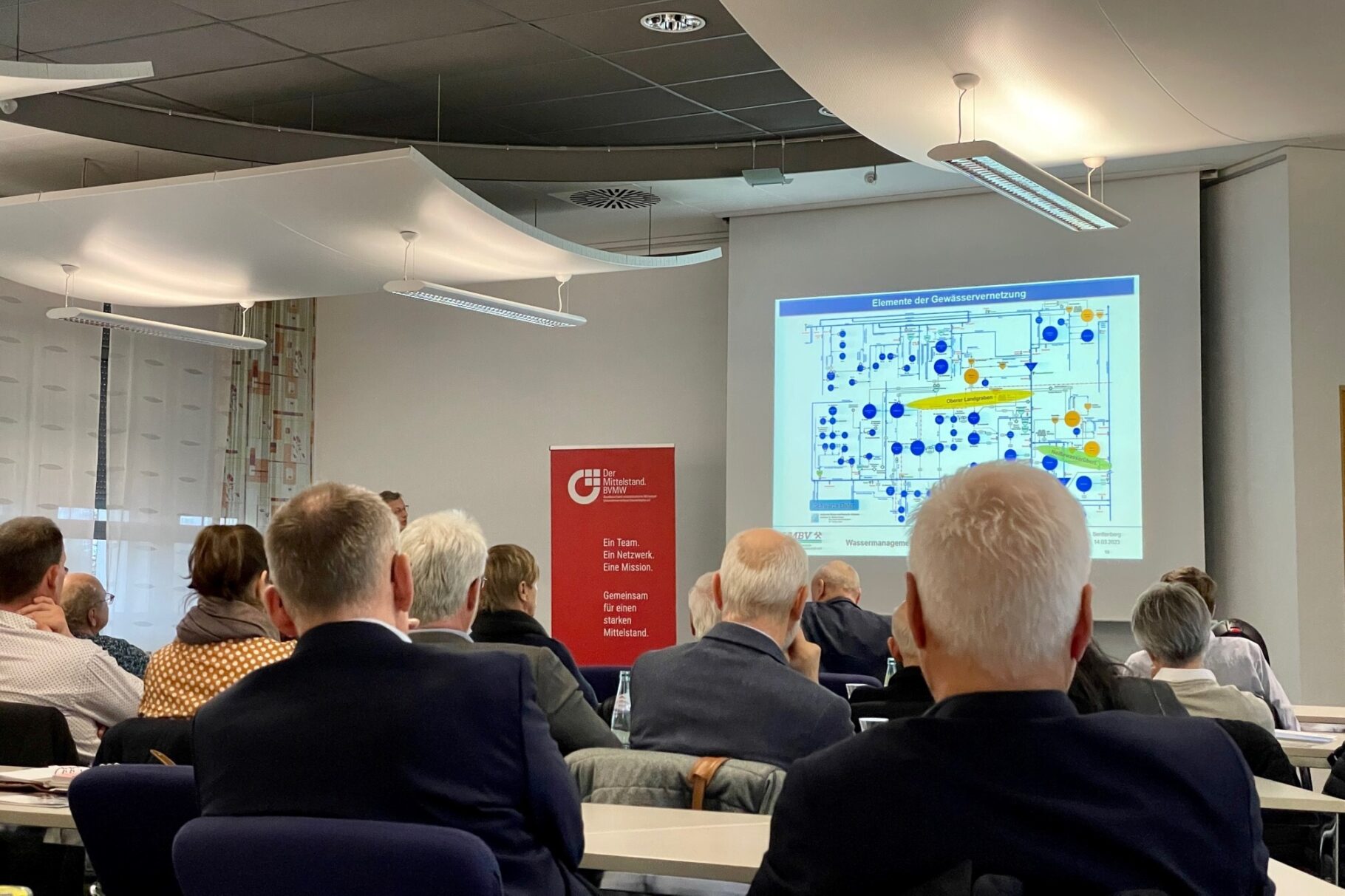 interessierte Gäste schauen sich eine Präsentation an