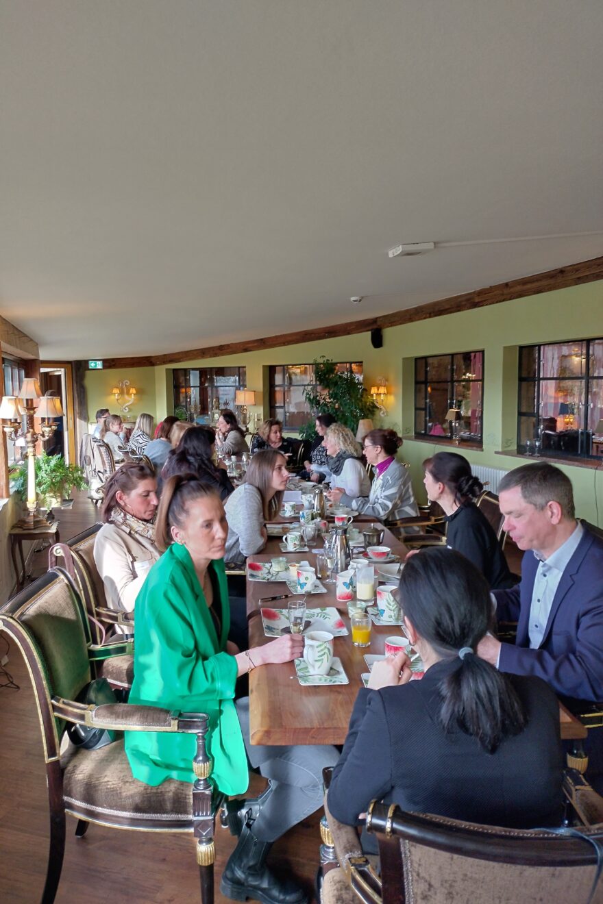 Menschen sitzen an einer Frühstückstafel