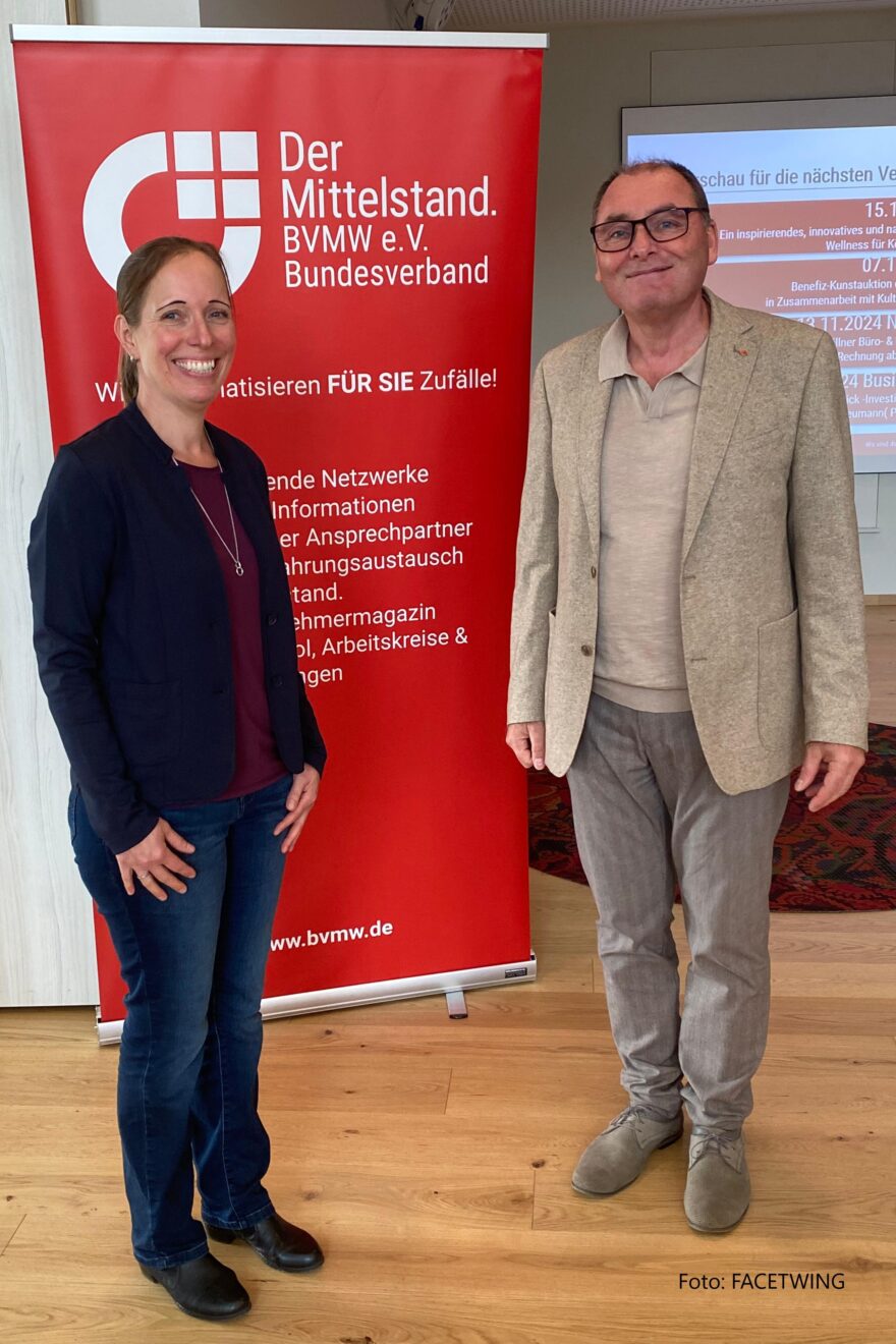 eine Frau und ein Mann stehen vor einem Plakat