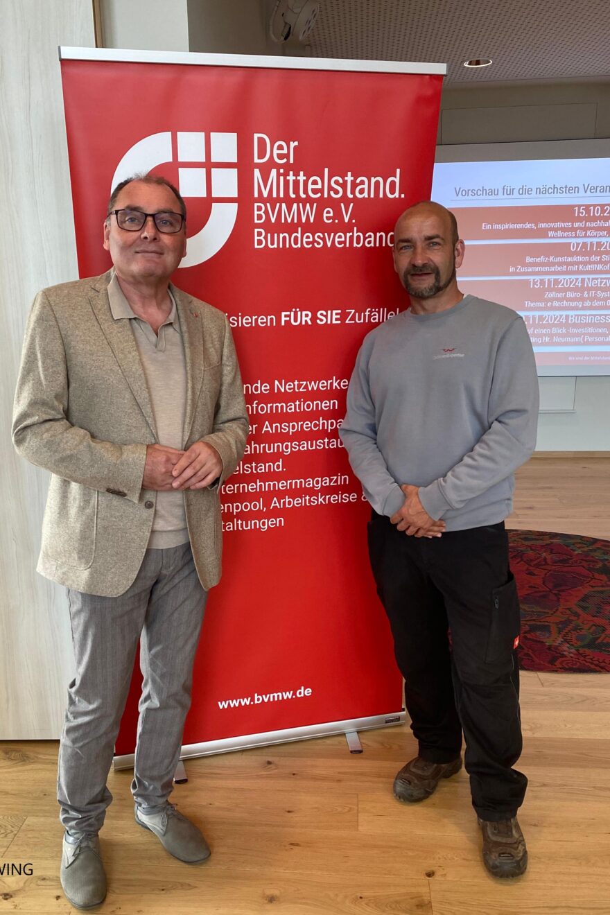 zwei Männer stehen vor einem Plakat