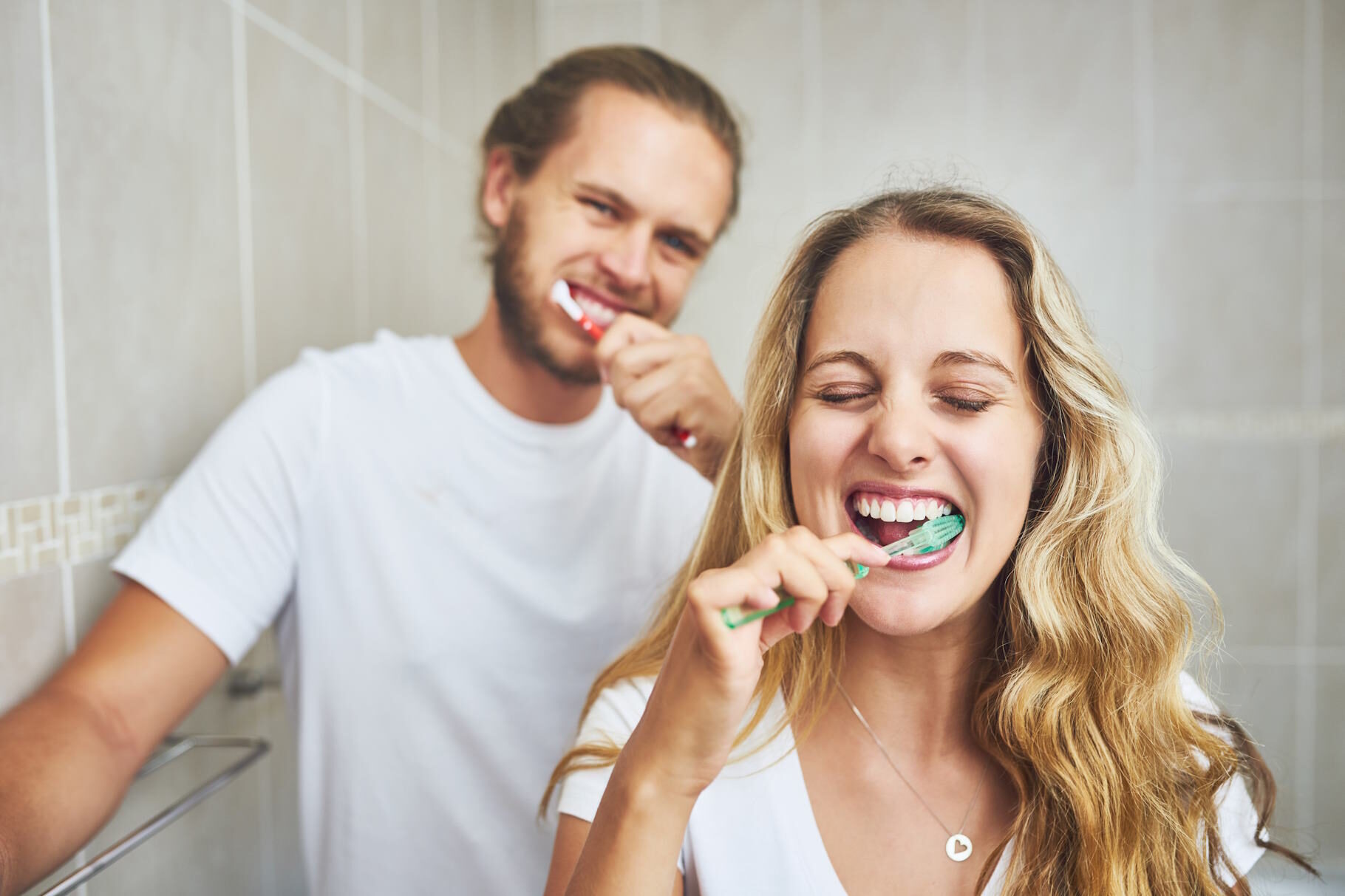 Ein Mann und eine Frau putzen gemeinsam Zähne