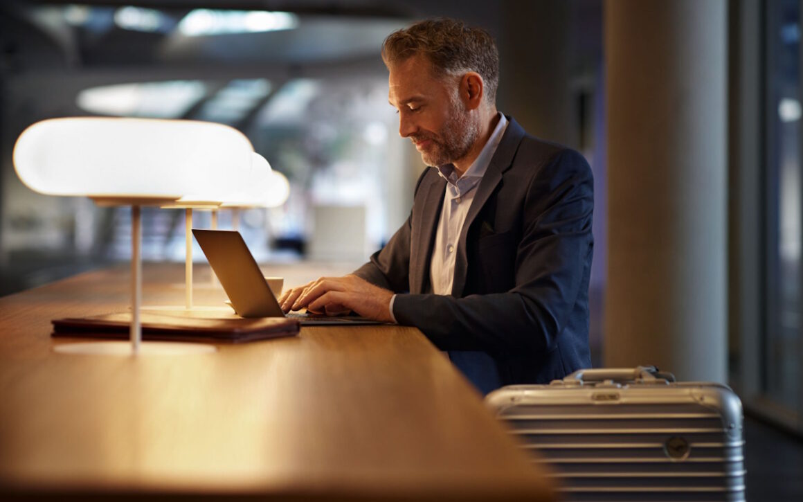 Ein Flugreisender arbeitet an einem Tisch am Laptop