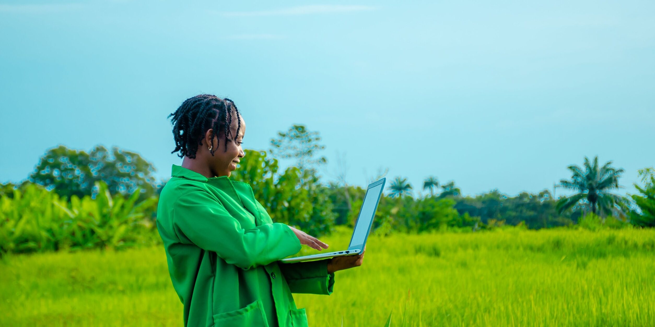 frau mit laptop vor tropenwald