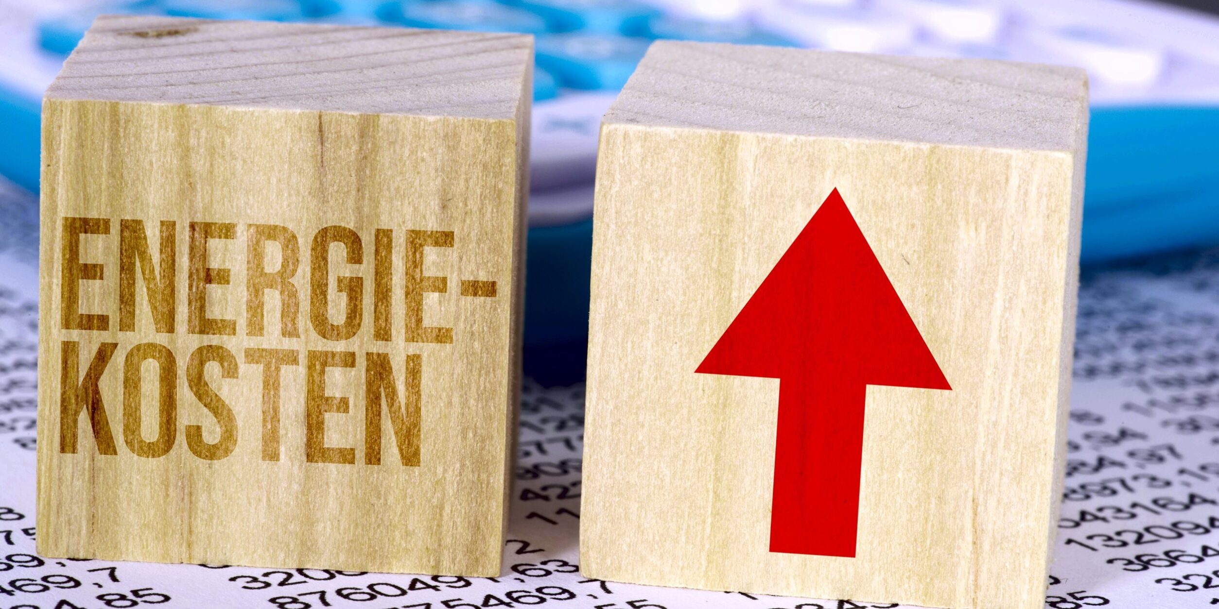 Würfel mit dem wort energiekosten und pfeil nach oben