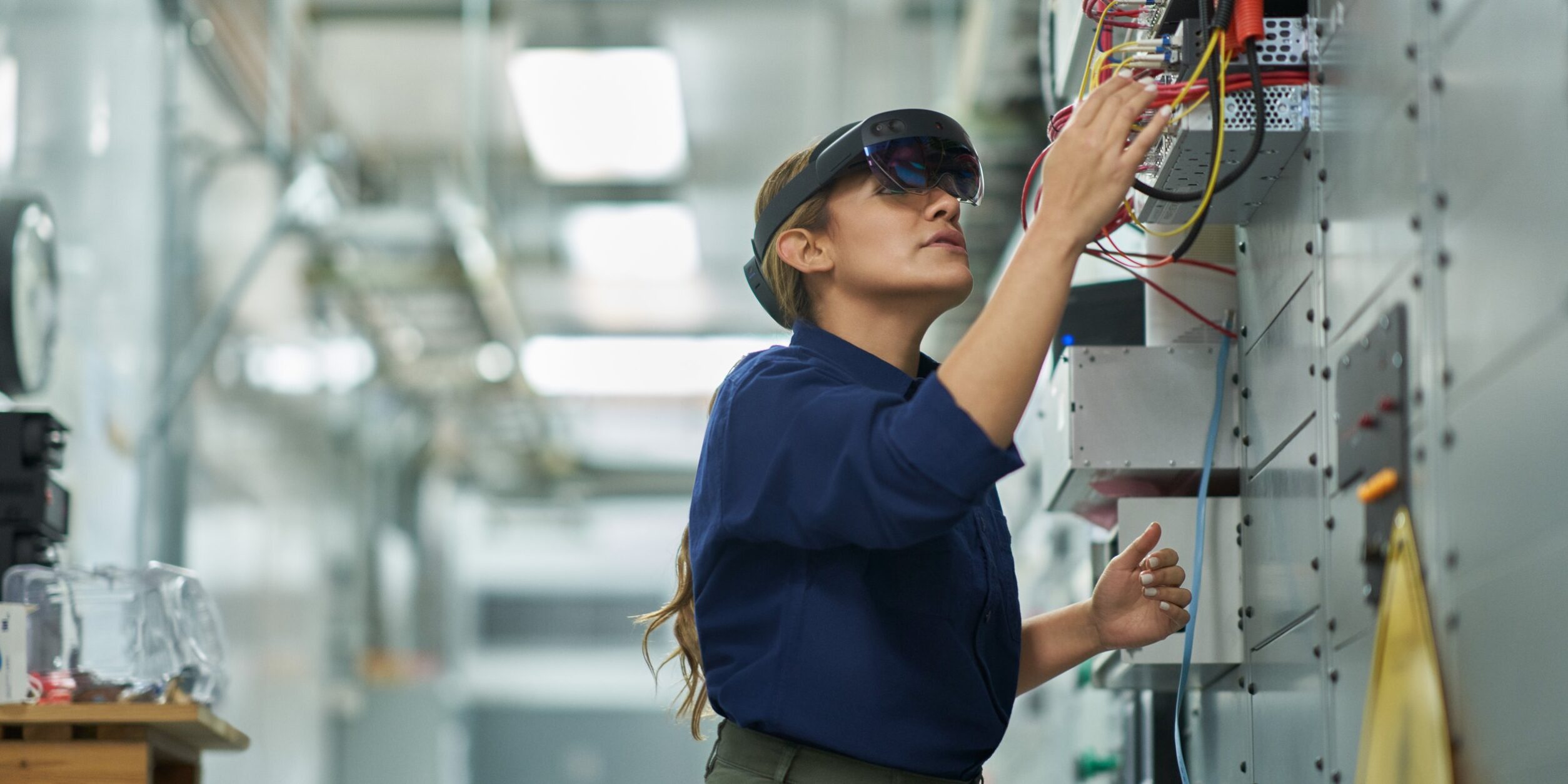 Eine Mitarbeiterin inspiziert den Serverraum eines elektrischen Umspannwerks in einem Windpark mithilfe der HoloLens 2.