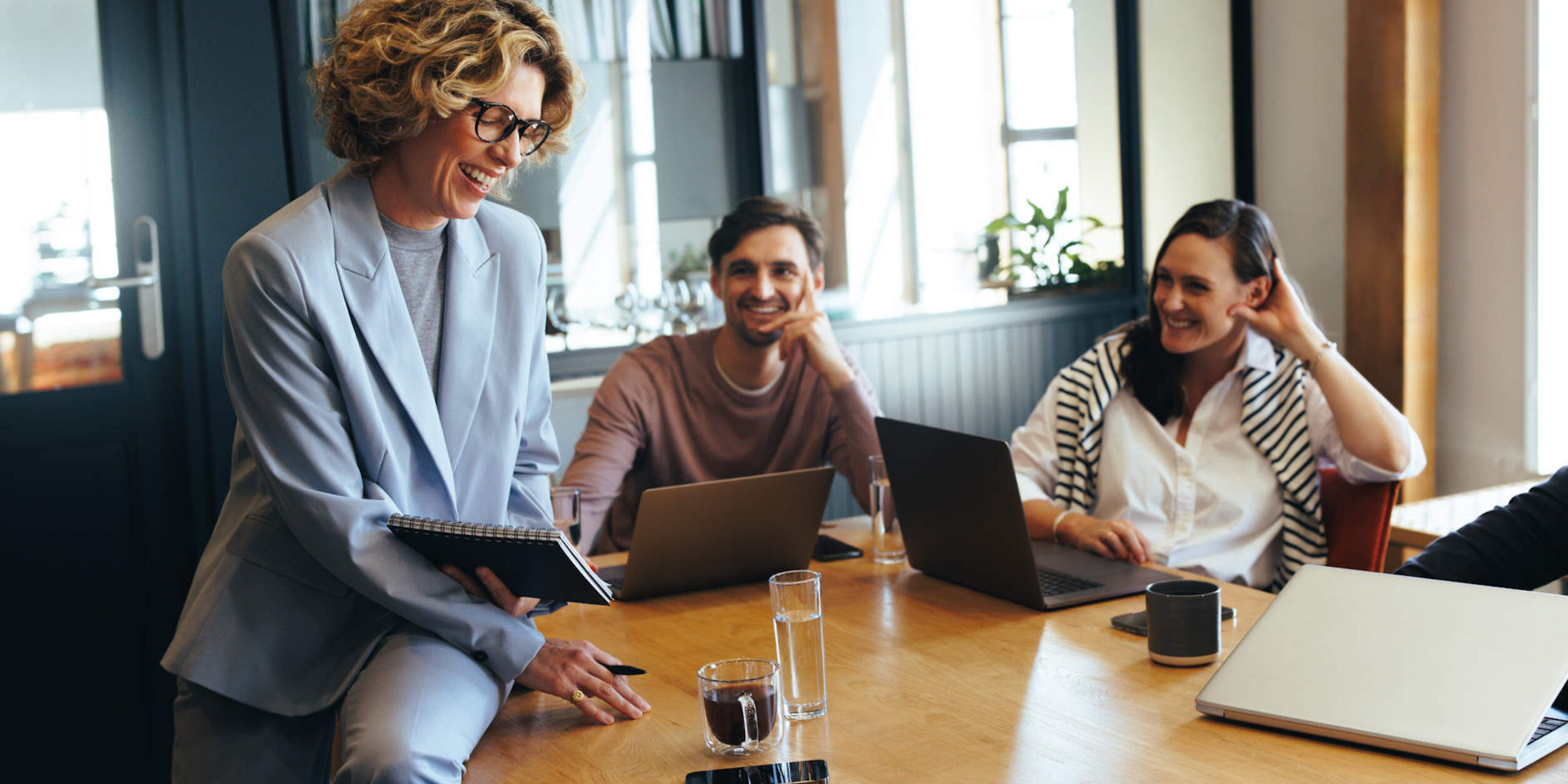 3 Personen sitzen in einem Besprechungsraum