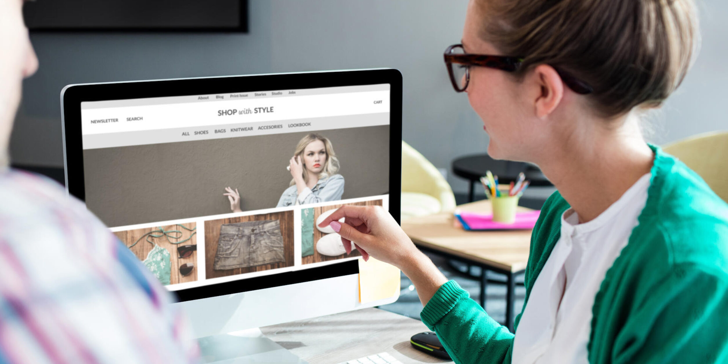 Zwei Personen blicken auf einem Laptop, auf dem eine Website mit einem Onlineshop geöffnet ist