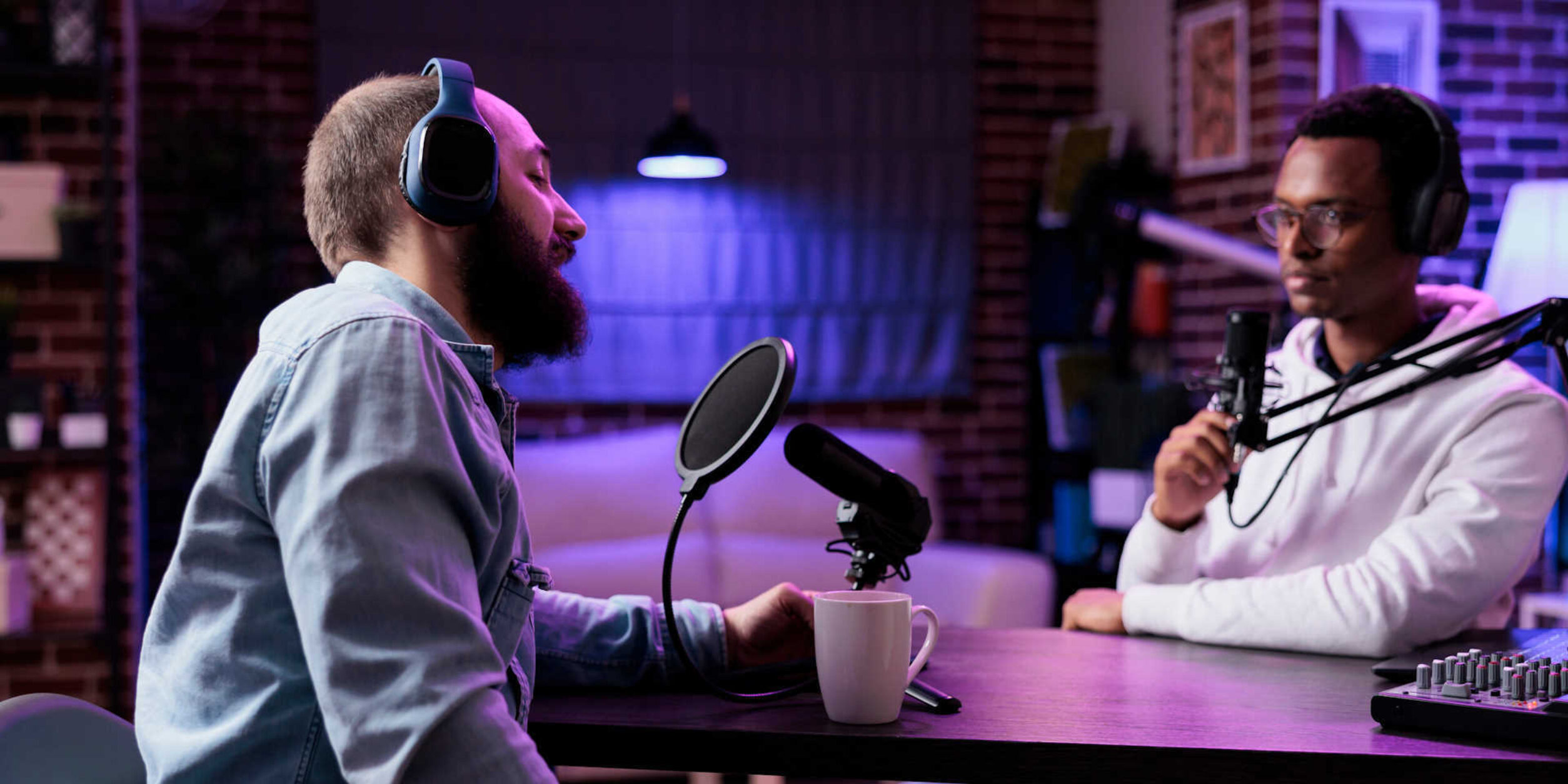 2 Männer sitzen in einem Aufnahmestudio für Podcasts