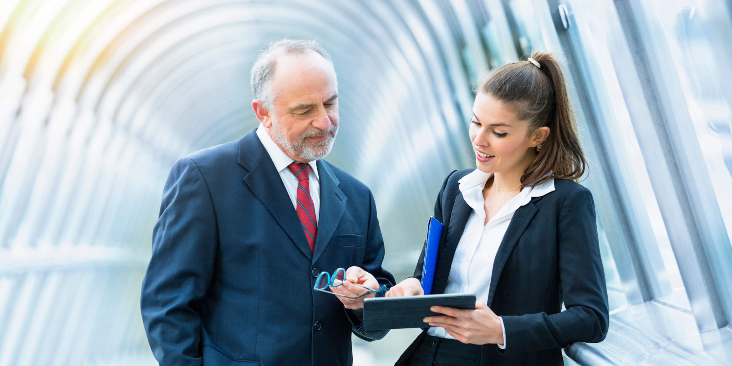 Zwei Personen blicken im Gespräch zusammen auf ein Tablet