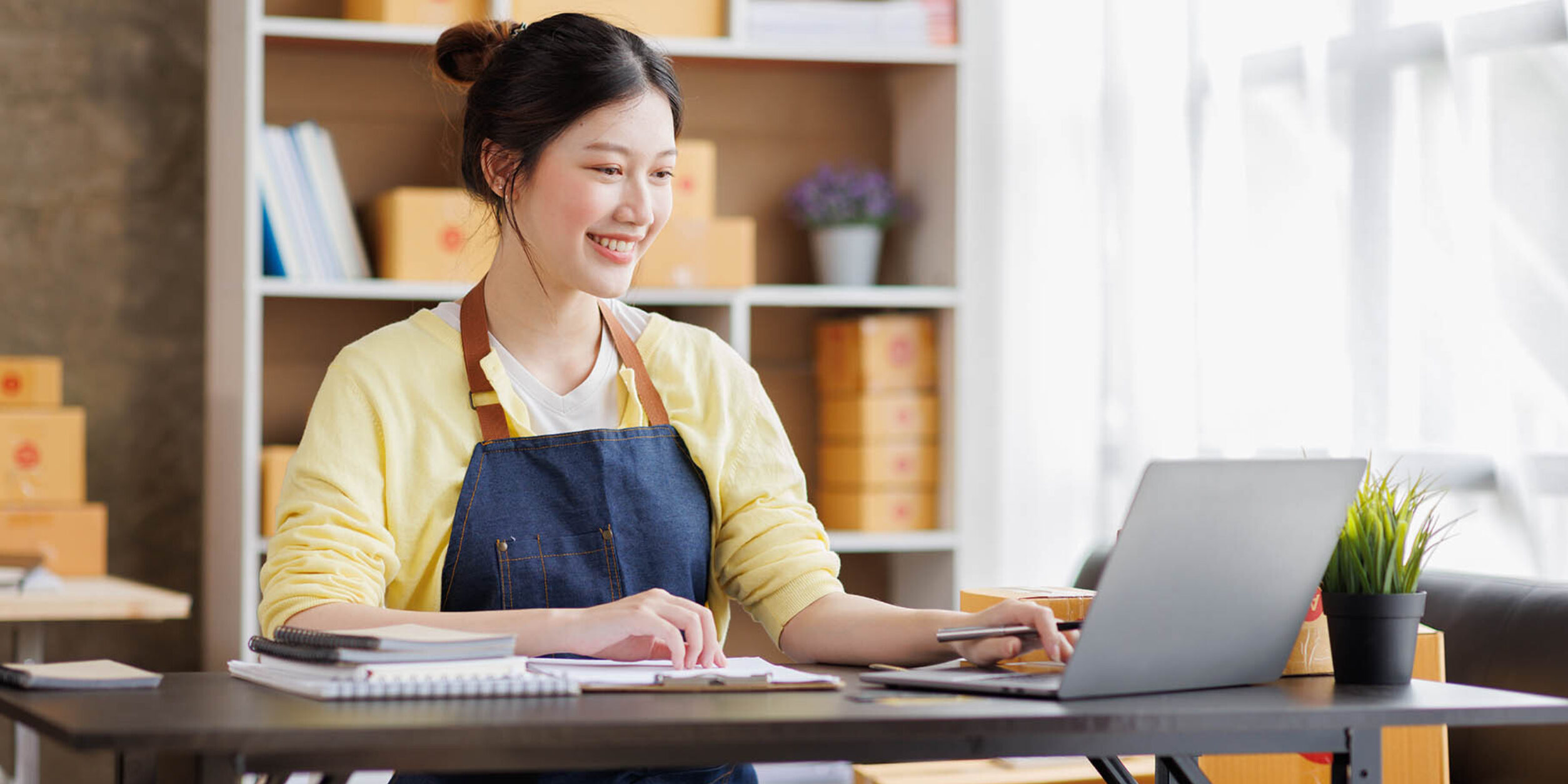 Frau mit Schürze am Schreibtisch