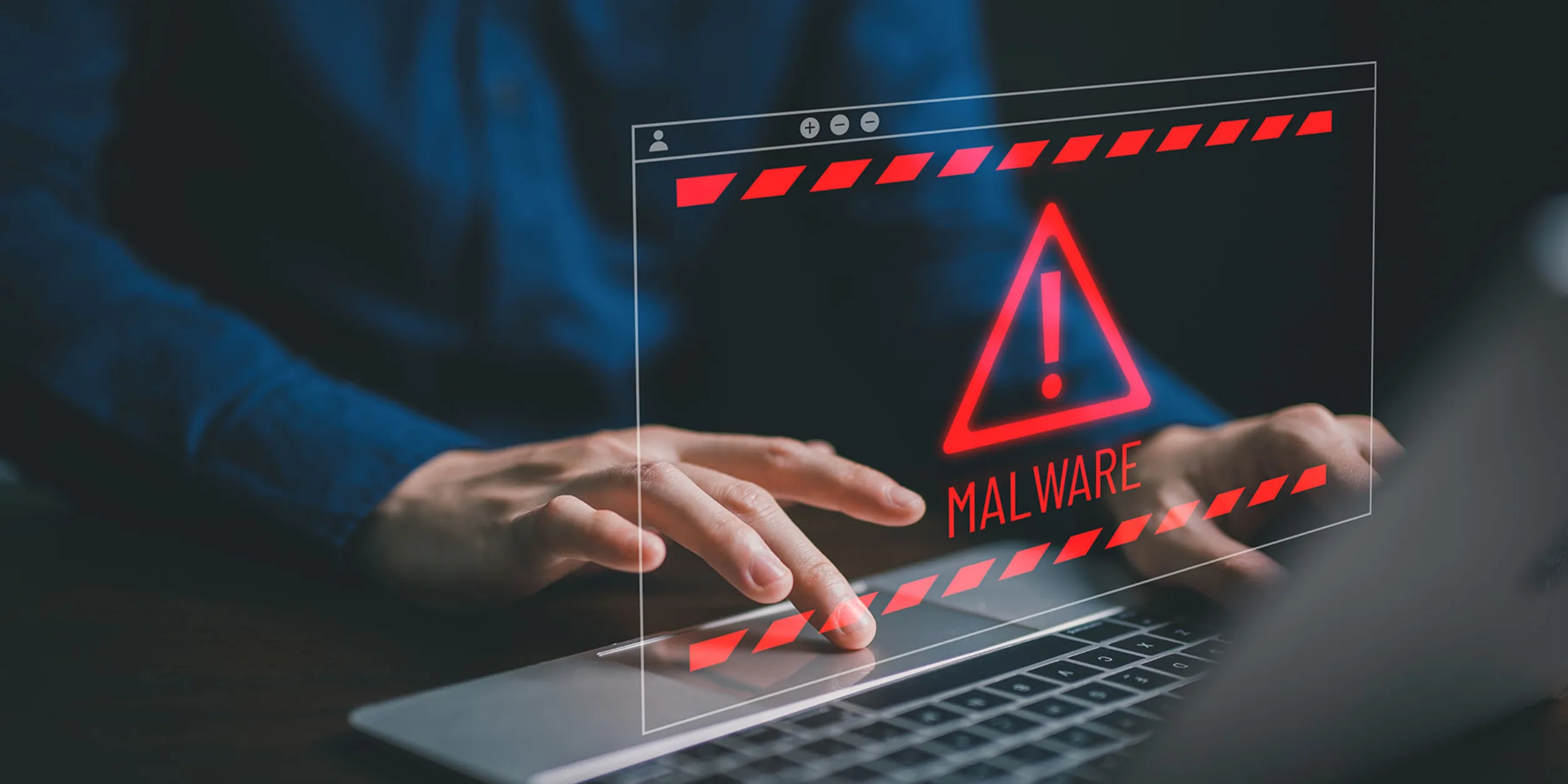 Malware Warnung über einer Tastatur mit tippenden Händen