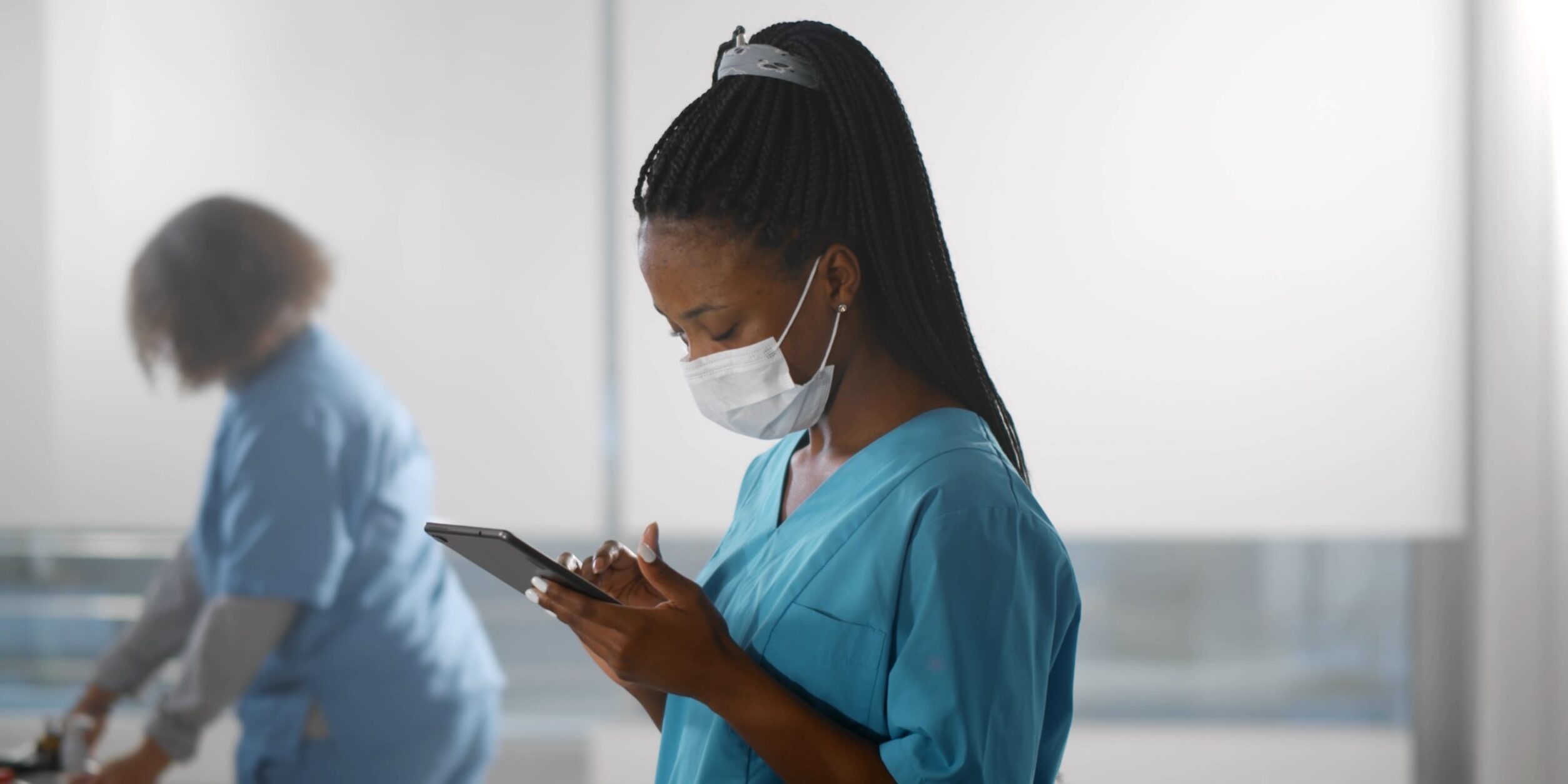 Eine Pflegerin schaut auf ihr Smartphone