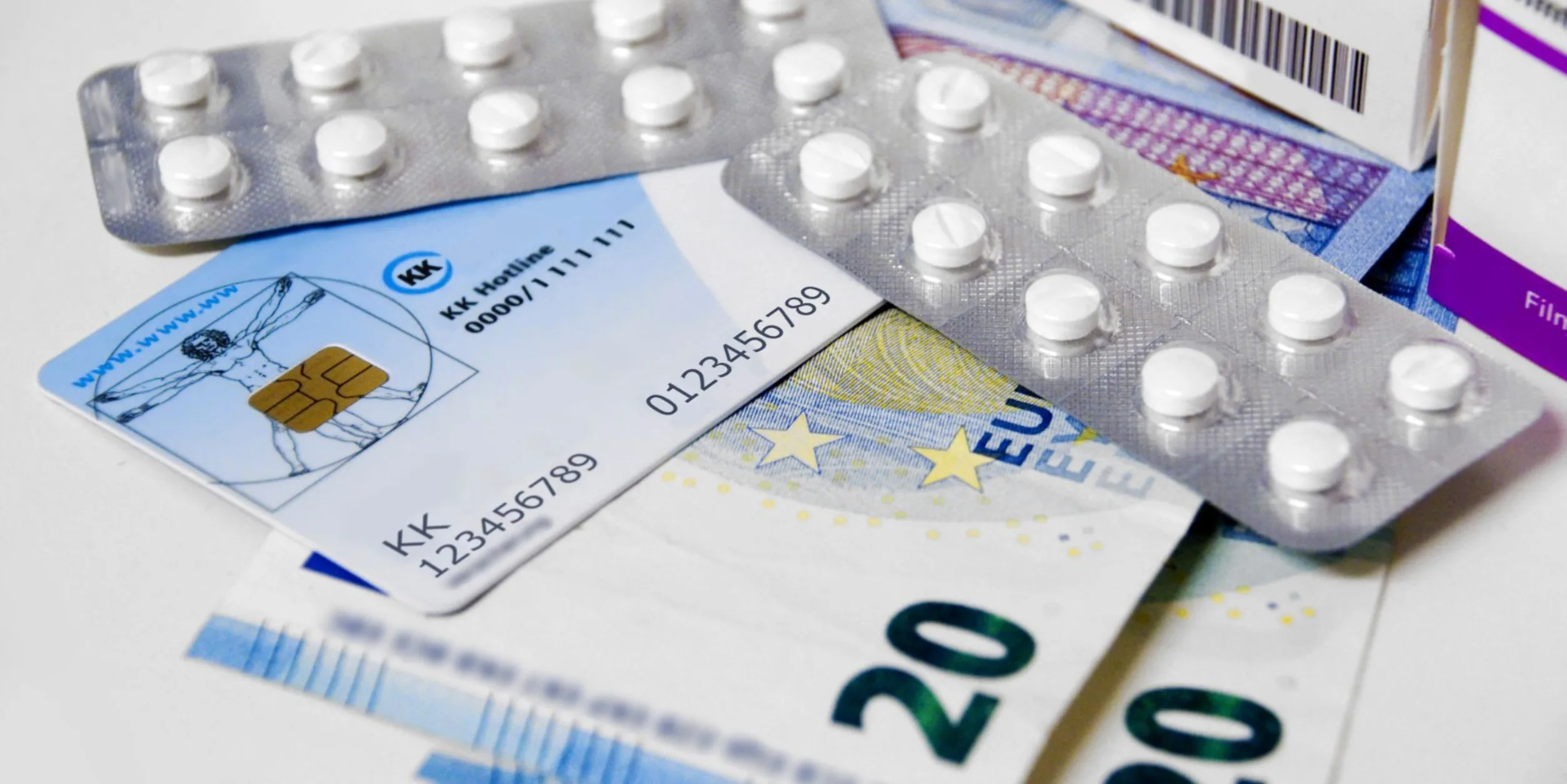 Geldscheine, eine Krankenversicherungskarte und Blister mit Pillen