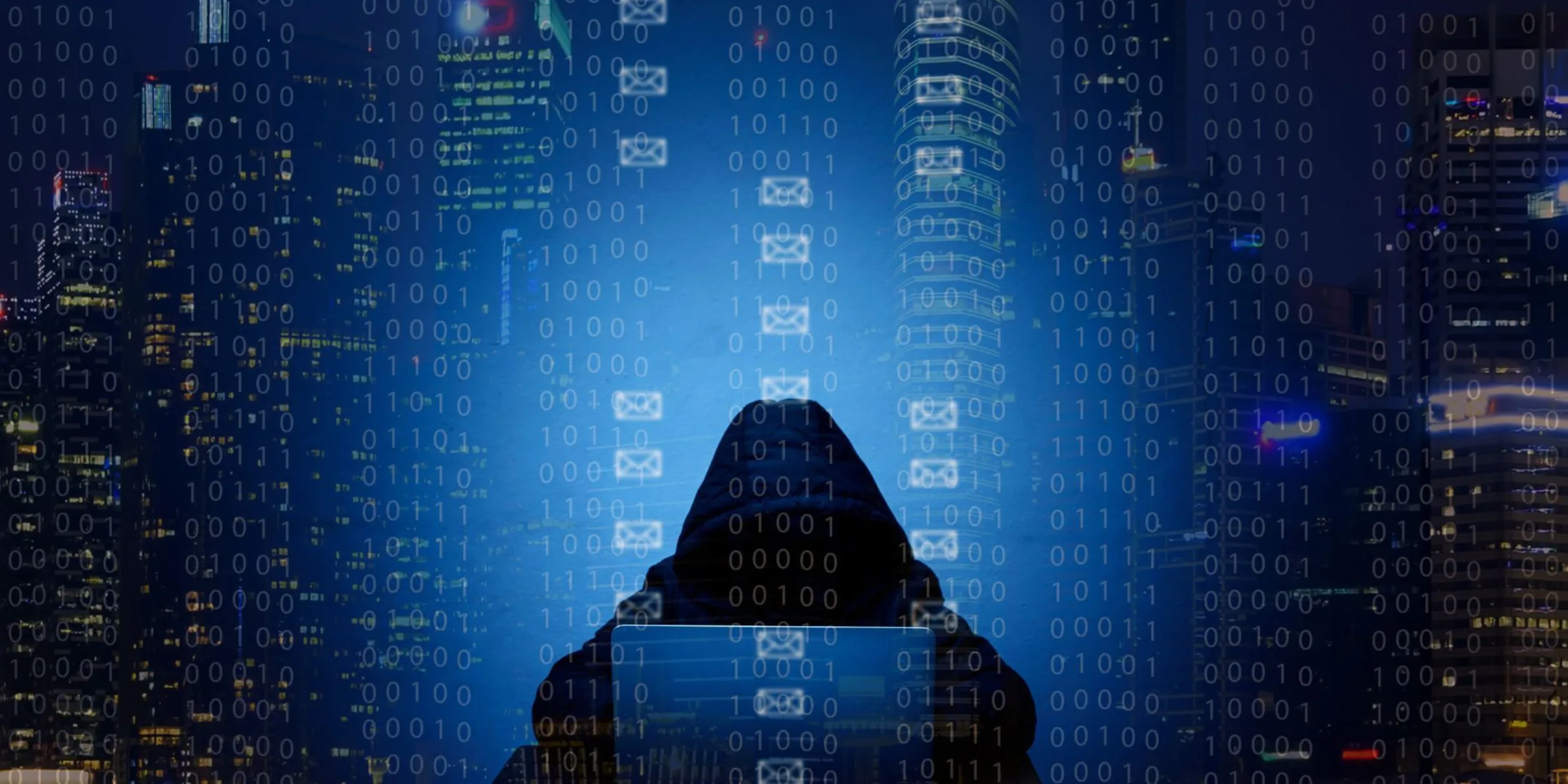 Ein Hacker sitzt vor einem Laptop im Dunkeln