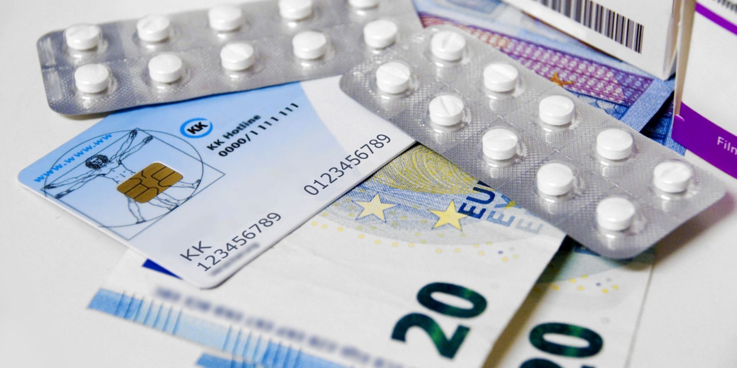 Geldscheine, eine Krankenversicherungskarte und Blister mit Pillen