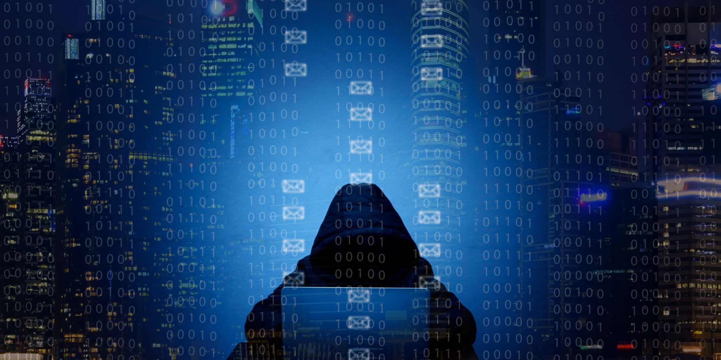 Ein Hacker sitzt vor einem Laptop im Dunkeln