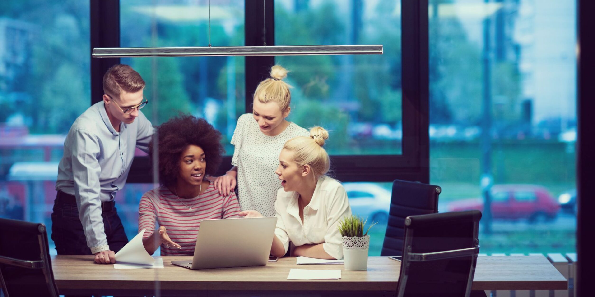 Mehrere junge Unternehmer und Unternehmerinnen sind in einer lockeren Besprechung