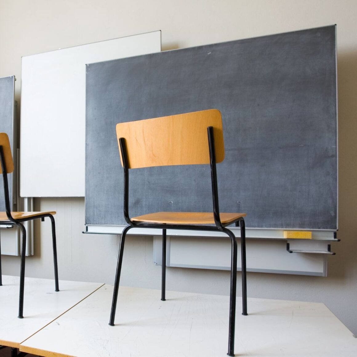 Stühle stehen in einem Klassenzimmer auf den Tischen
