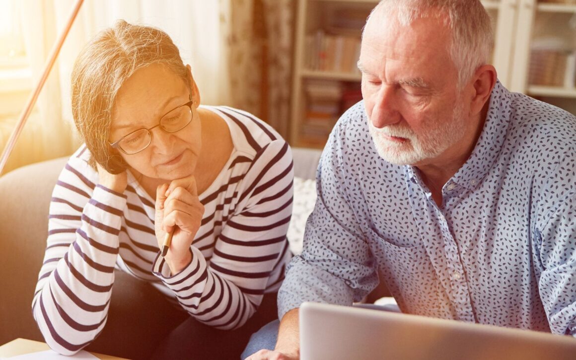 Zwei Personen kurz vor der Rente schauen zusammen auf Unterlagen