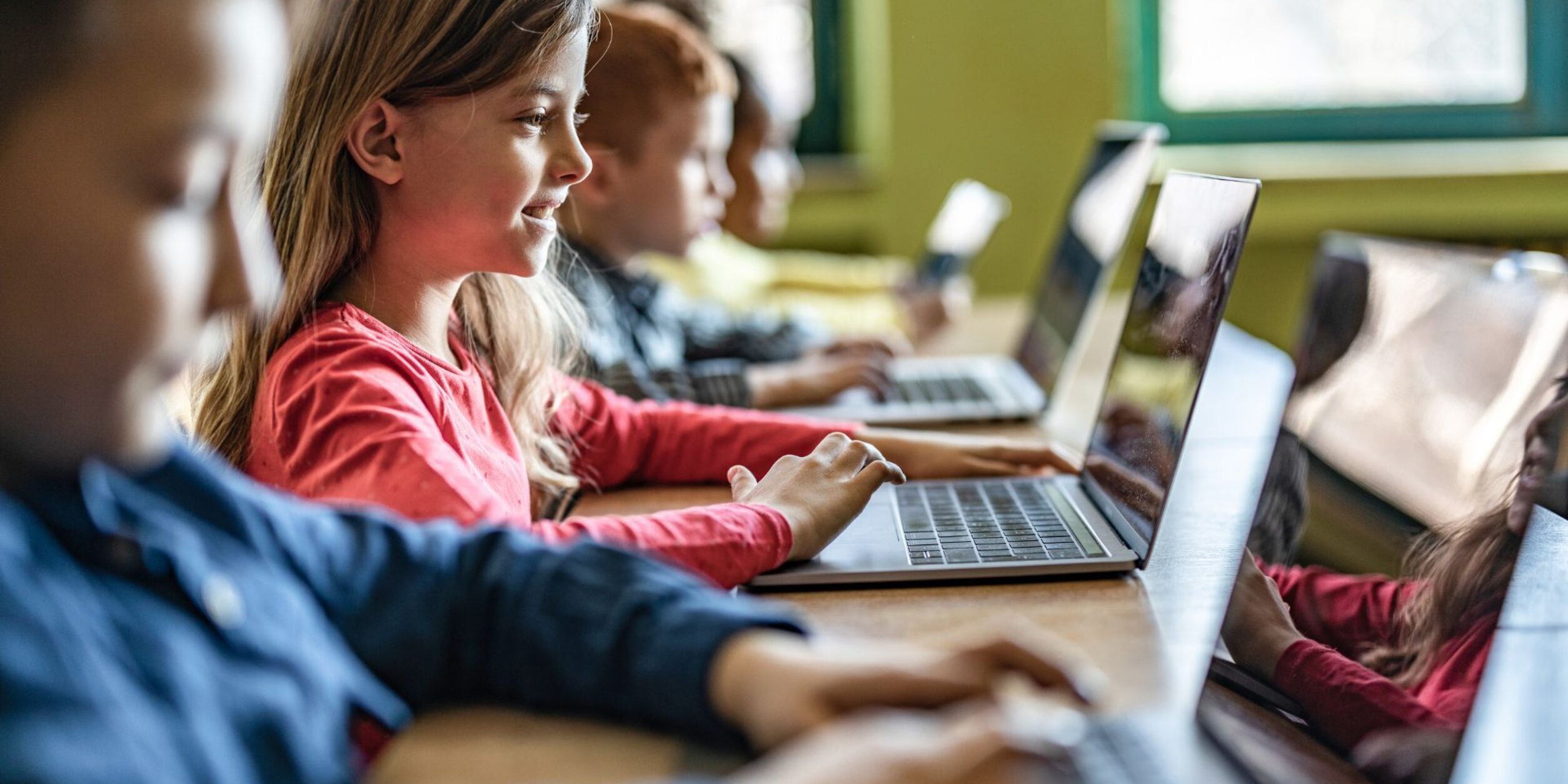 Schulkinder, die an Laptops arbeiten