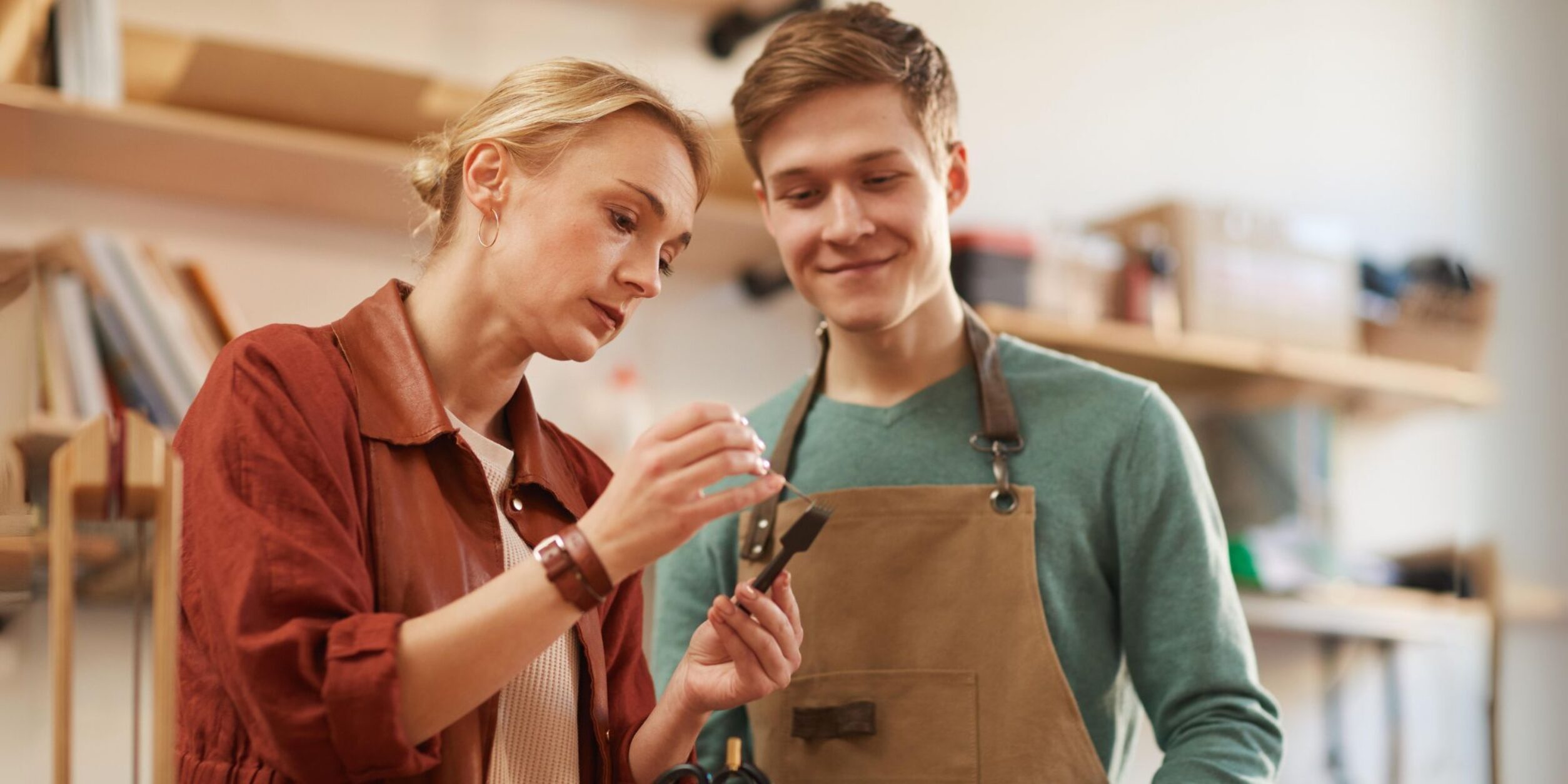 Unternehmerin unterrichtet jungen Lehrling