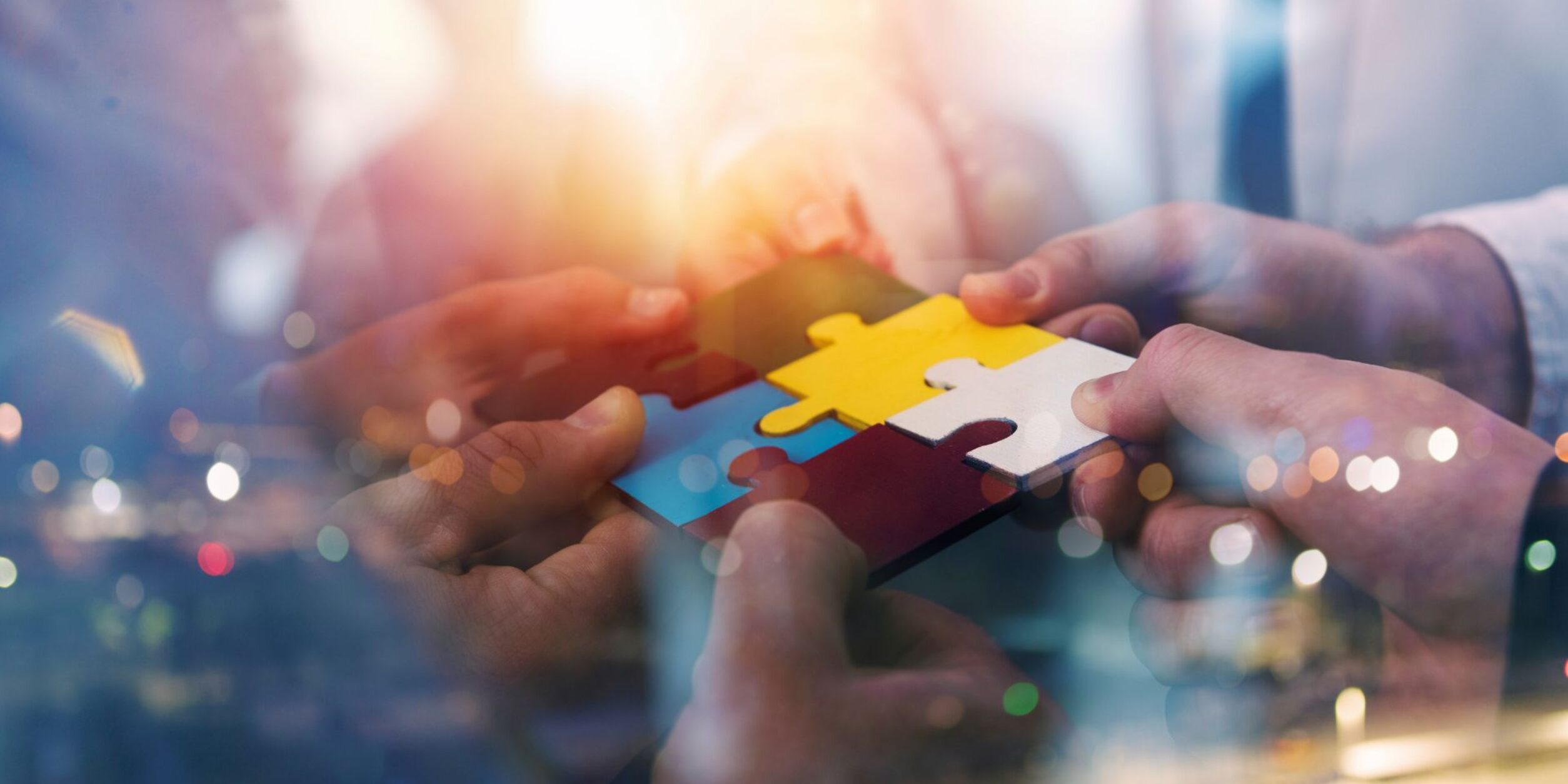 mehrere Personen setzen ein Puzzle zusammen