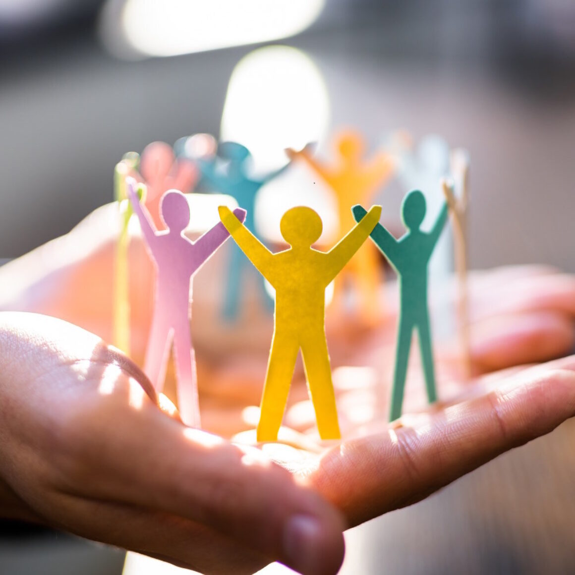 Eine Person hat eine gebastelte Menschenkette auf der Hand liegen