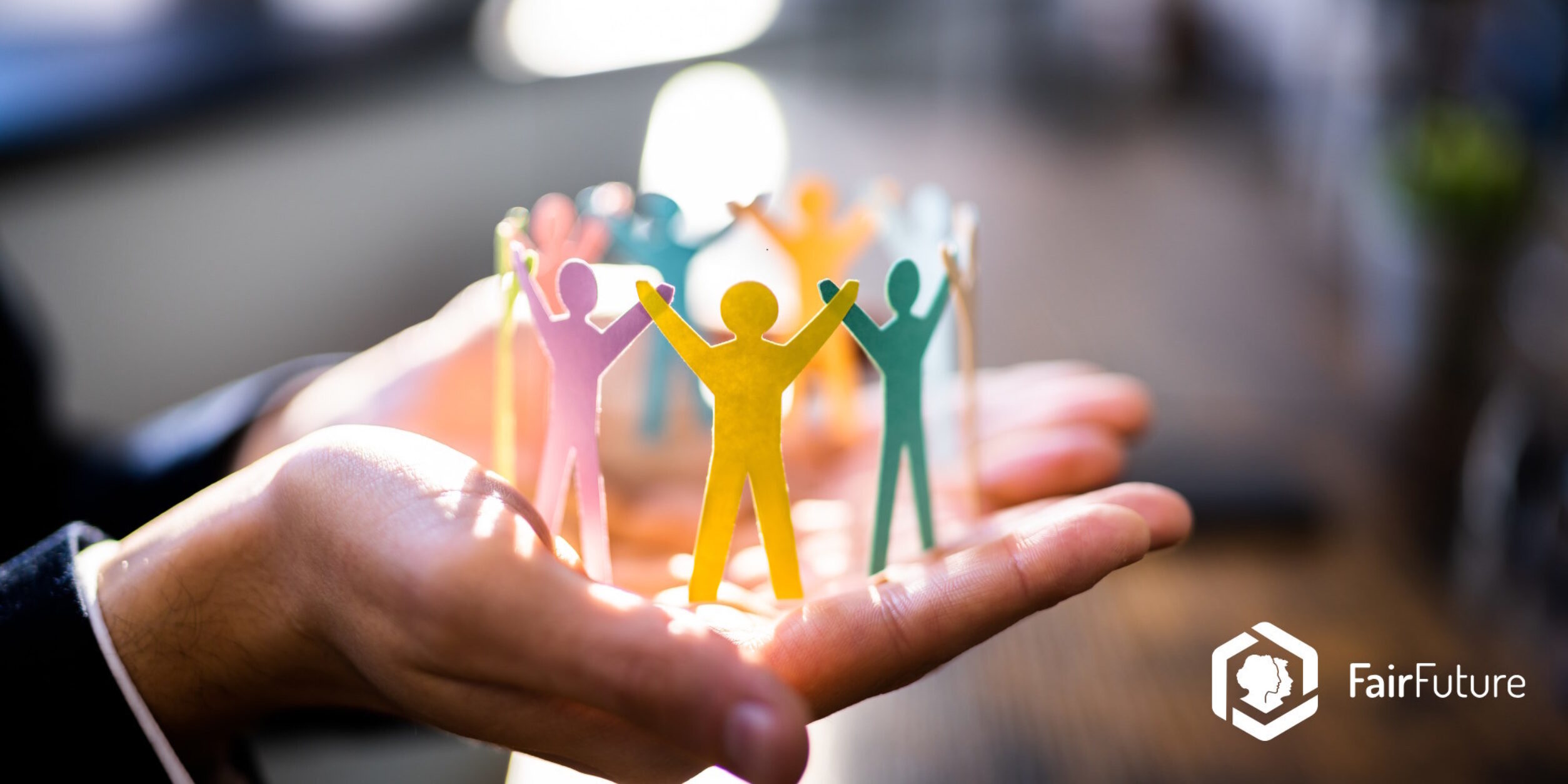 Eine Person hat eine gebastelte Menschenkette auf der Hand liegen