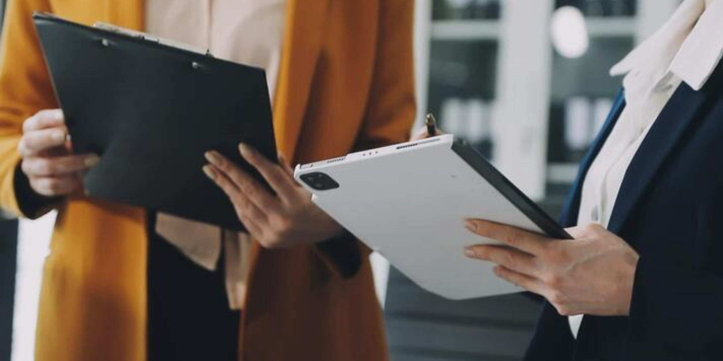 Two business people holding a clipboard and writing on it free video