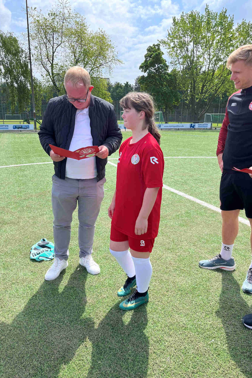 Kind mit Fortuna Köln Mitarbeitern