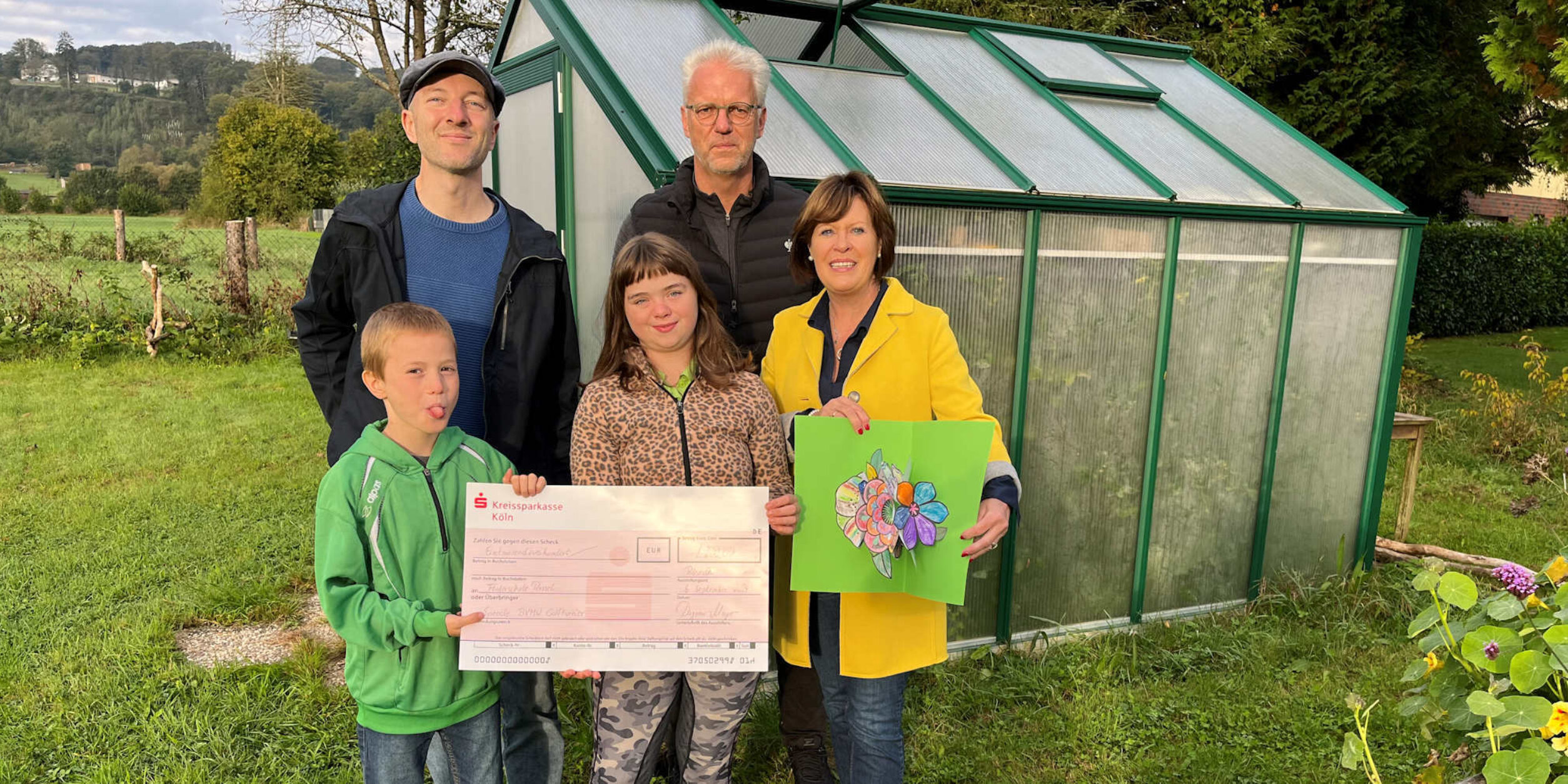 Scheckübergabe mit Kindern und Lehrern