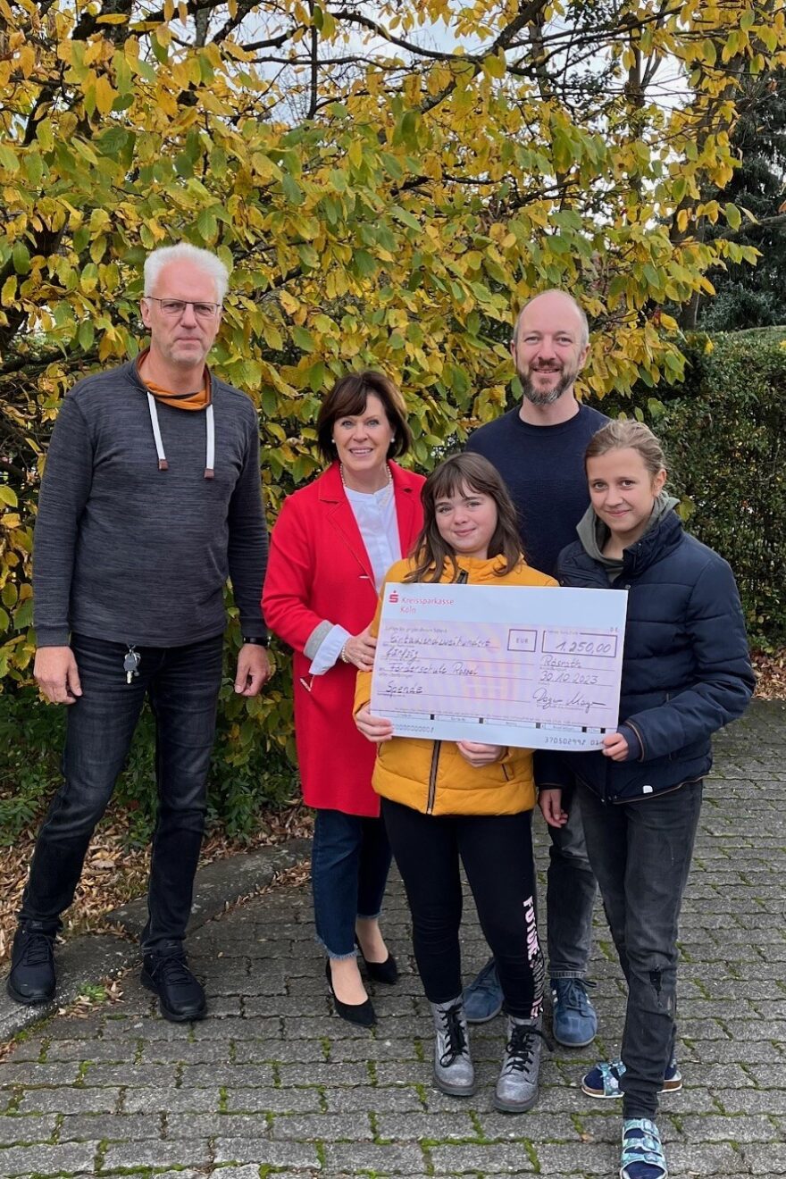 Dagmar Mayer mit Kindern und Betreuern und einem Scheck