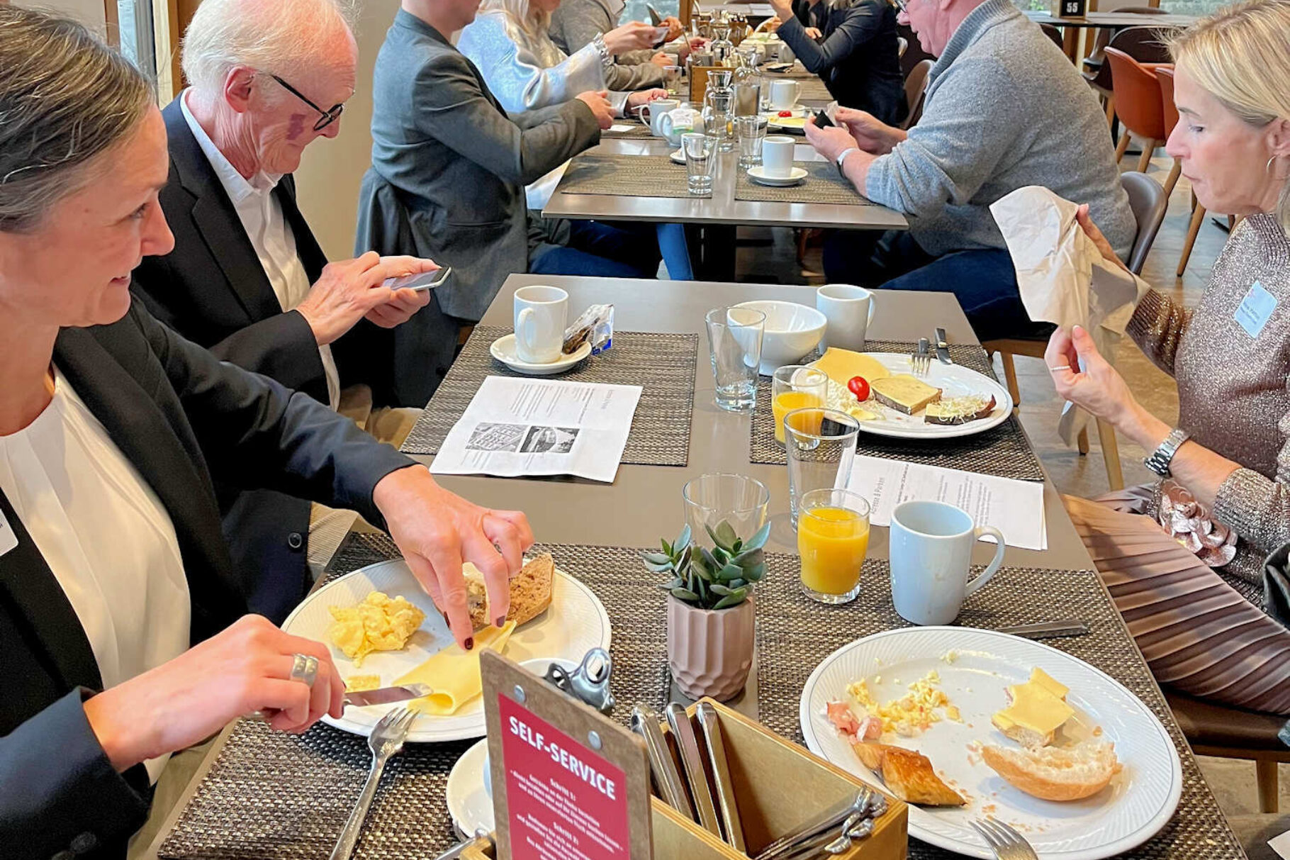 Tisch mit Teilnehmern beim Frühstück