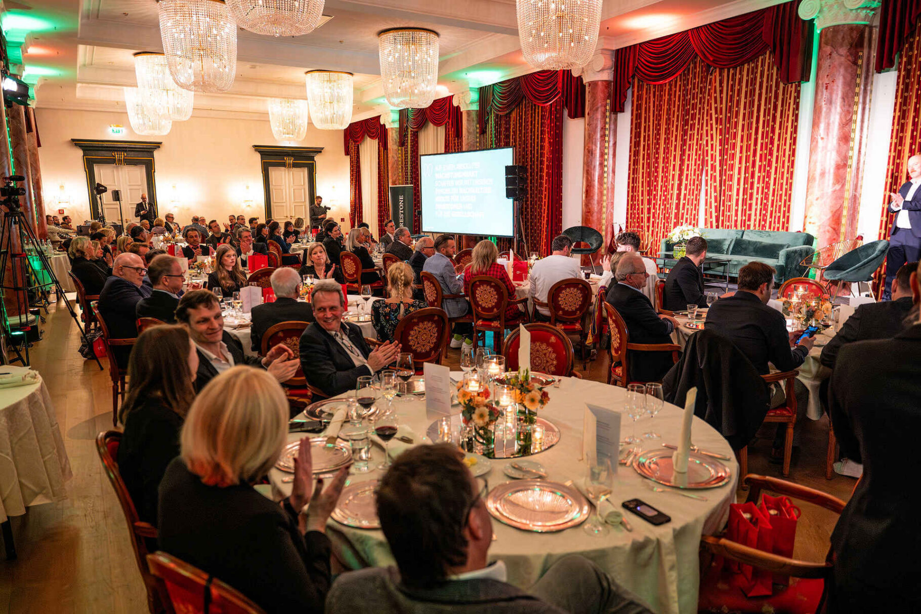 Saalübersicht mit Teilnehmern an Tischen