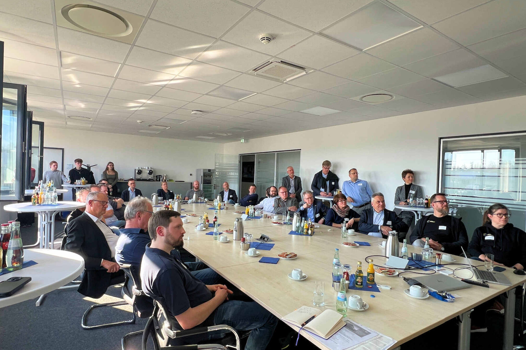 Teilnehmer am Tisch beim Vortrag