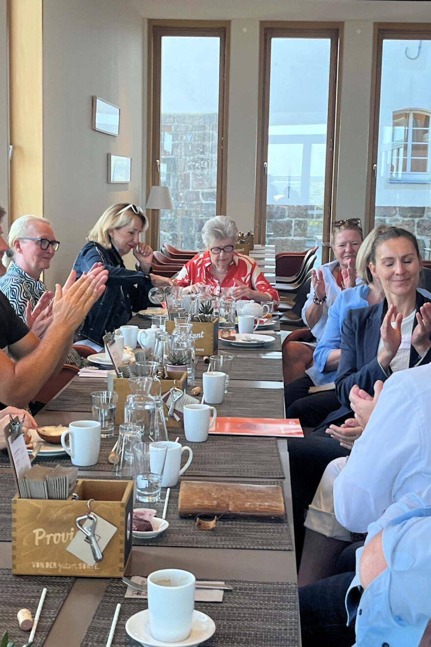 Teilnehmer um einen Tisch sitzend