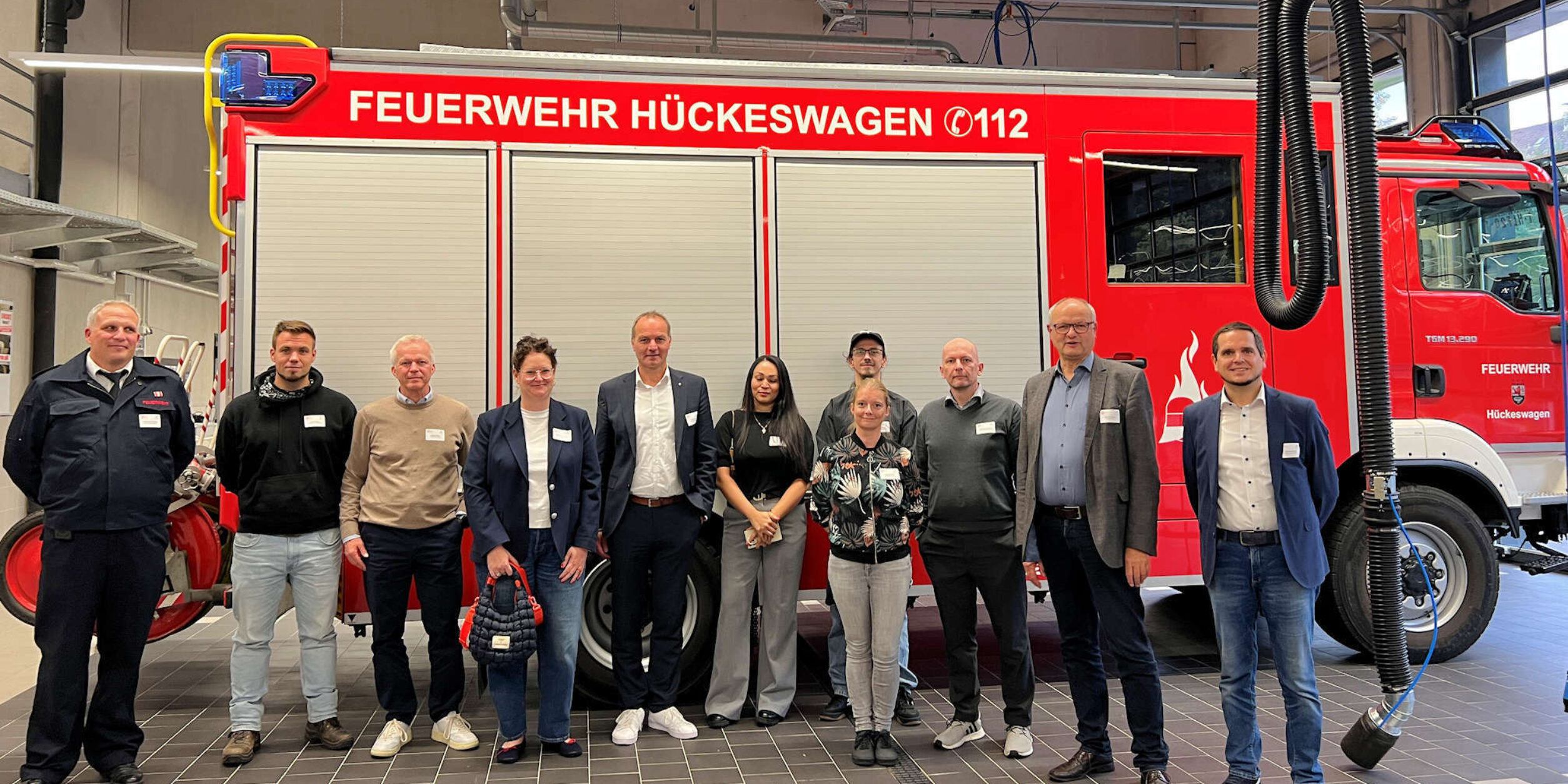 Teilnehmer vor einem Feuerwehrfahrzeug