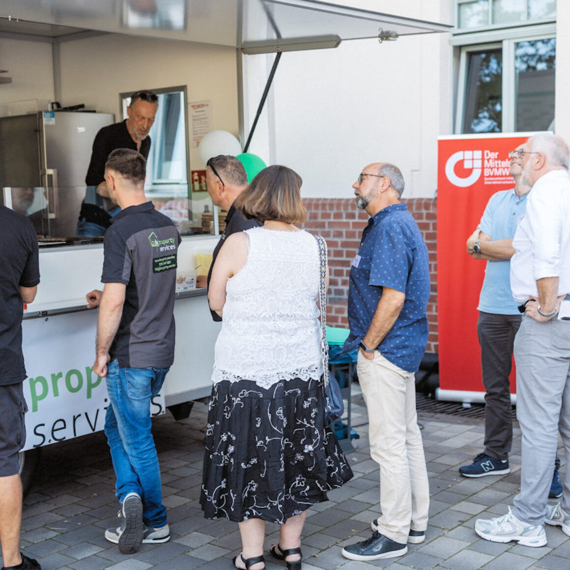 Teilnehmer vor dem Currywurst Stand