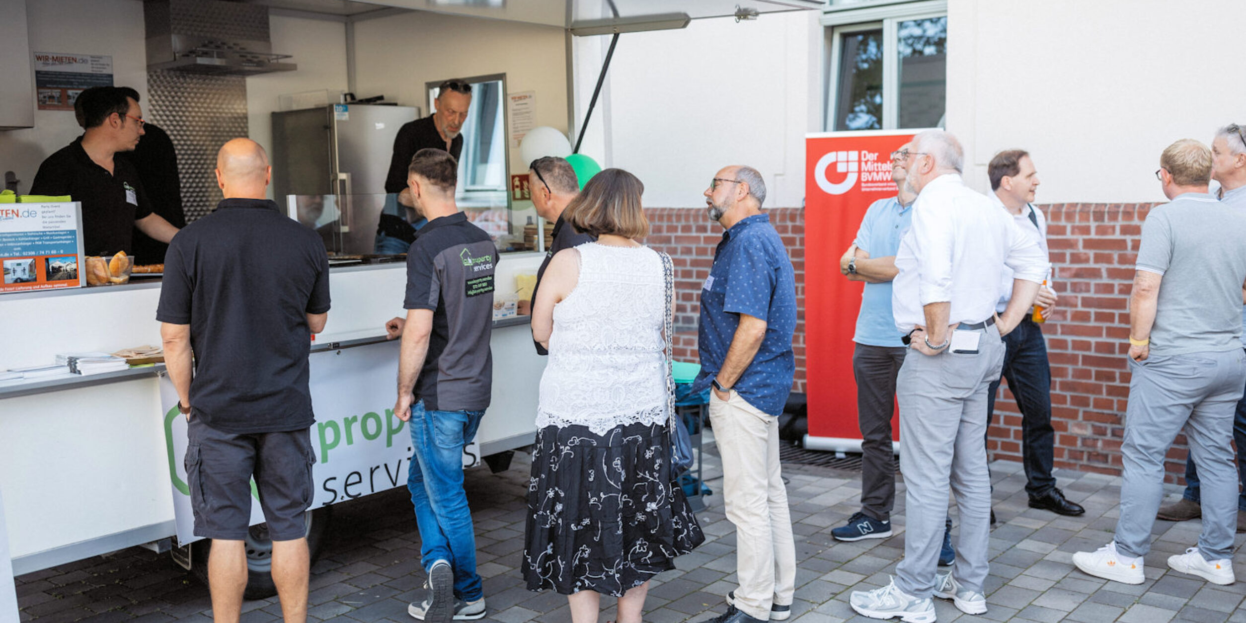 Teilnehmer vor dem Currywurst Stand