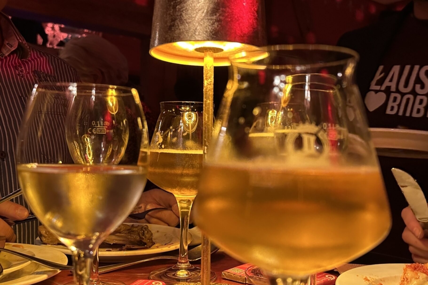 Drei Weingläser verteilt auf einem Tisch mit einer Lampe