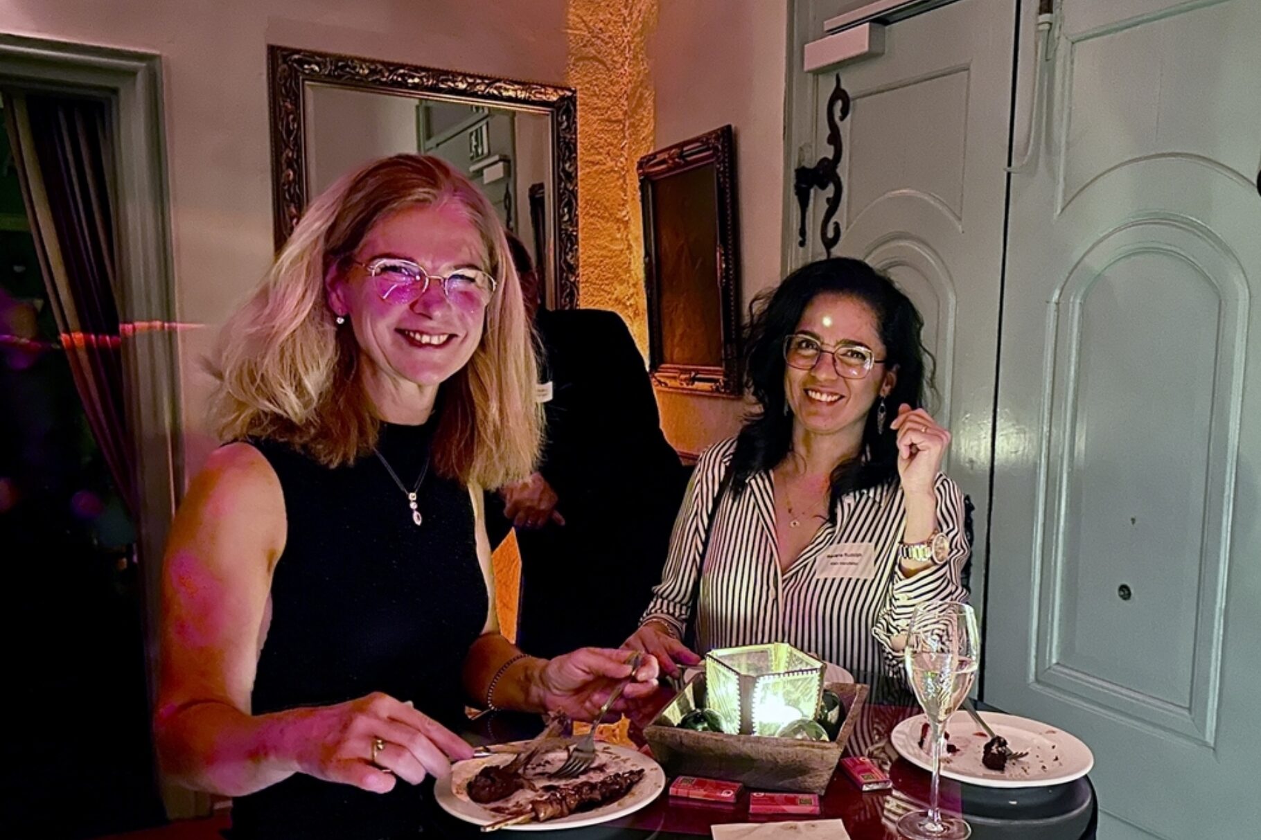 zwei Frau stehen um einen Tisch und genießen Speisen von einem Buffet