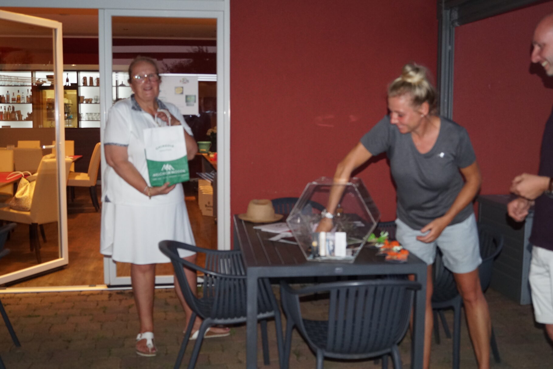 eine Frau zieht ein Los aus einer Lostrommel