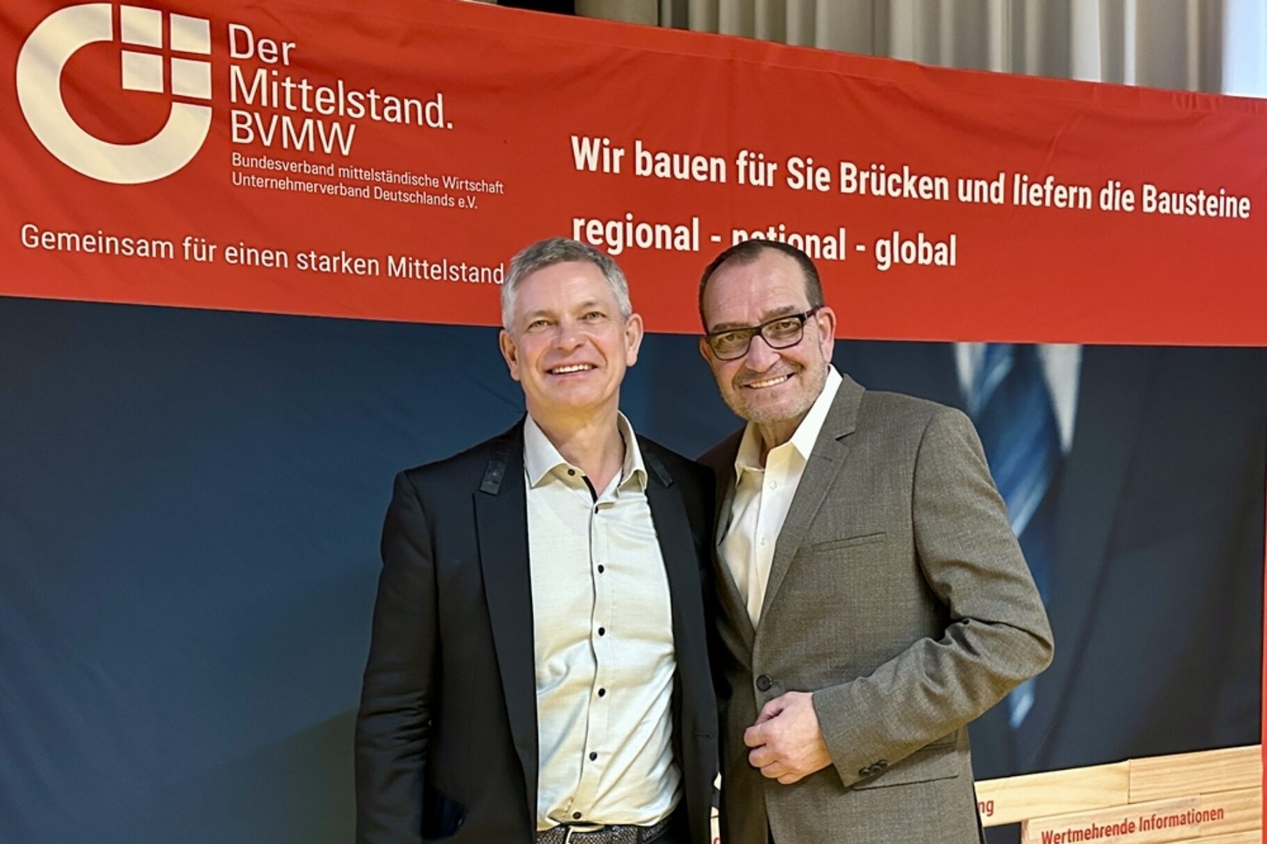 zwei Männer stehen vor einer Präsentationswand