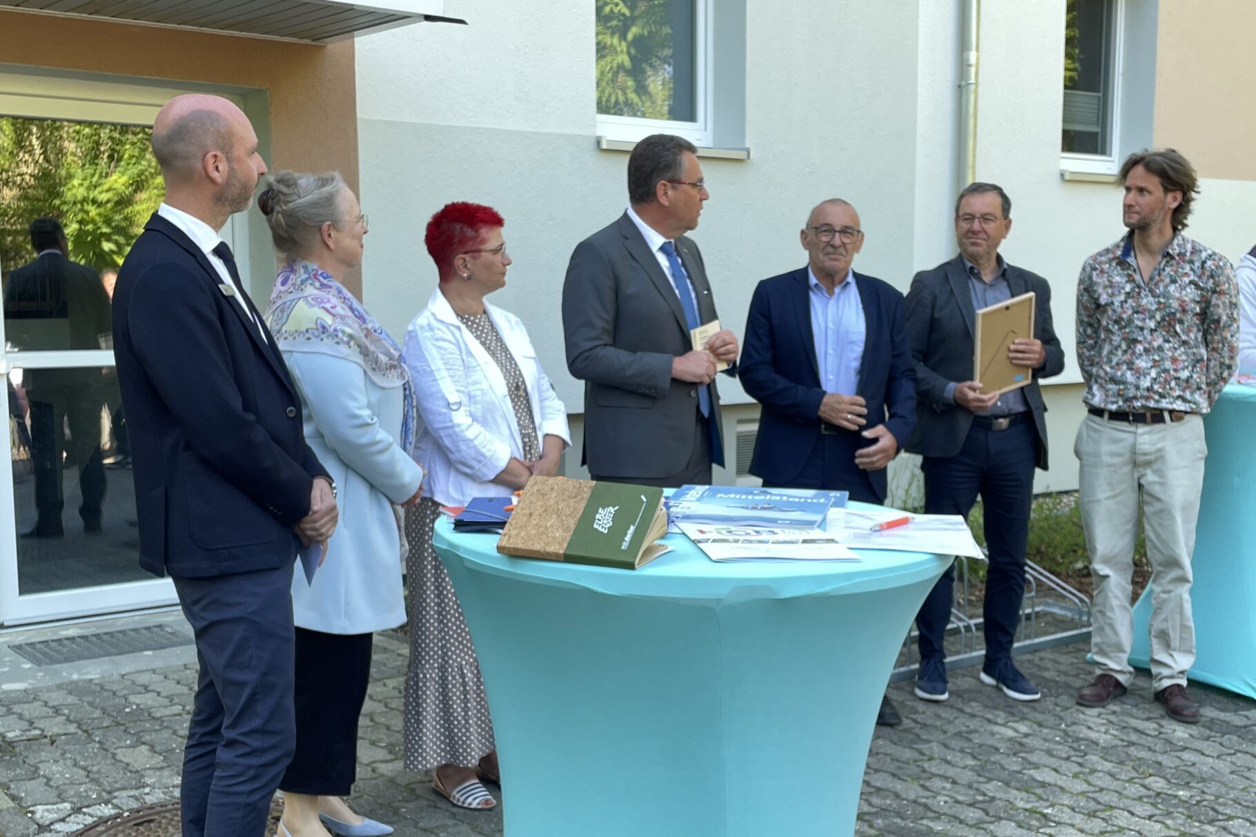 Menschen stehen um einen Stehtisch