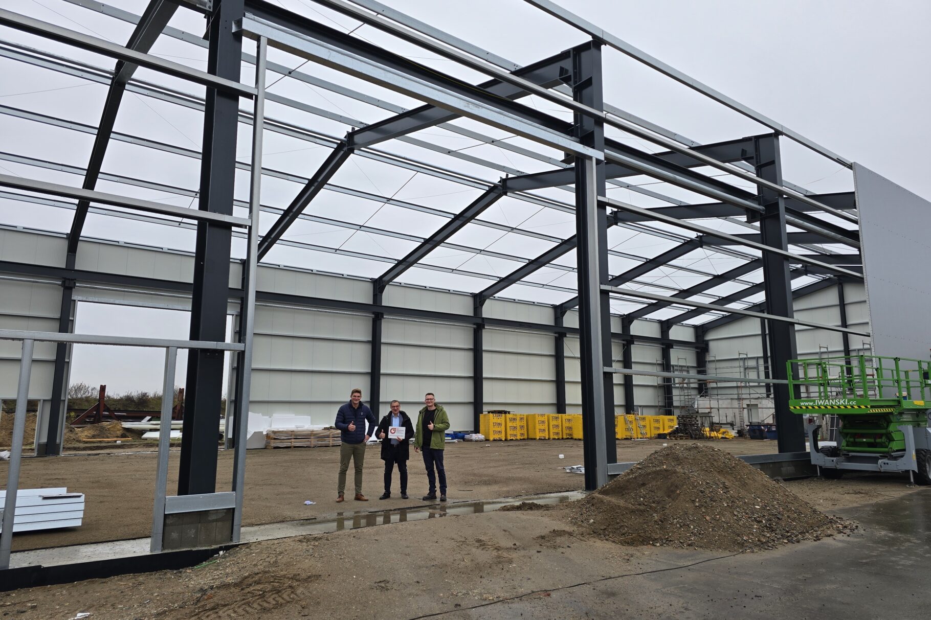 drei Männer stehen in der Mitte einer Halle