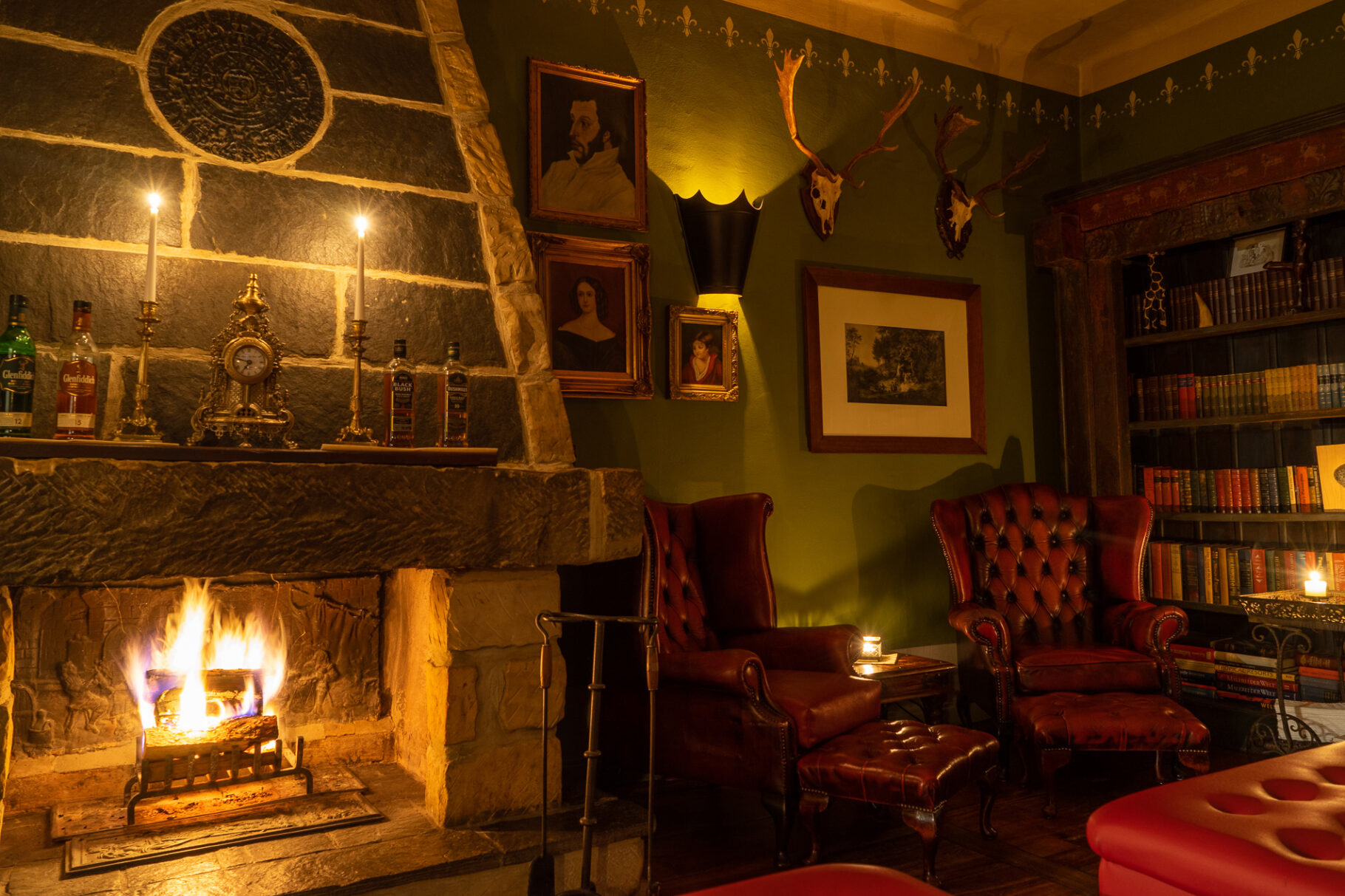 Kaminzimmer mit zwei Sesseln und einer Bücherwand