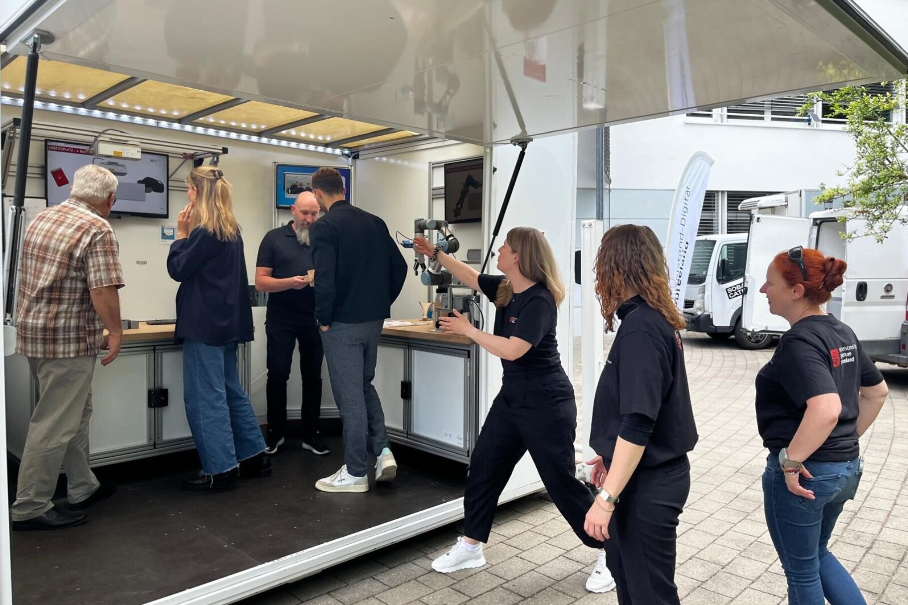 Menschen schauen sich einen Mobile Fabrik-Anhänger an